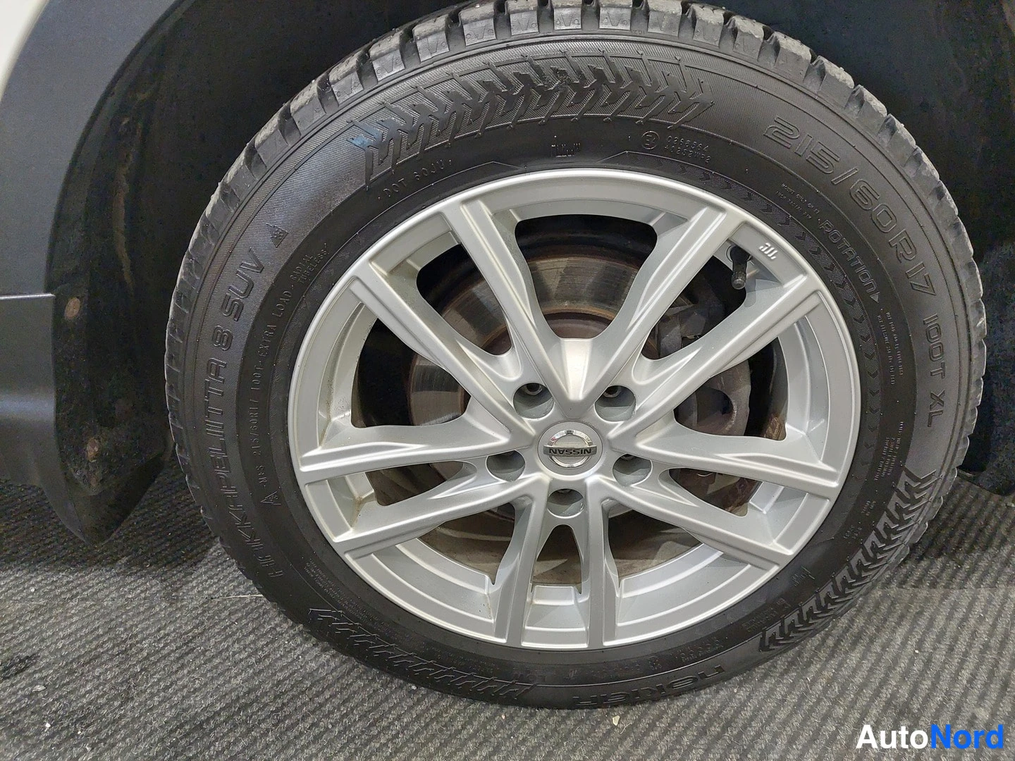 Yksityiskohta: Nissan-alumiinivanteen ja 215/60 R 17 talvirenkaan lähikuva.