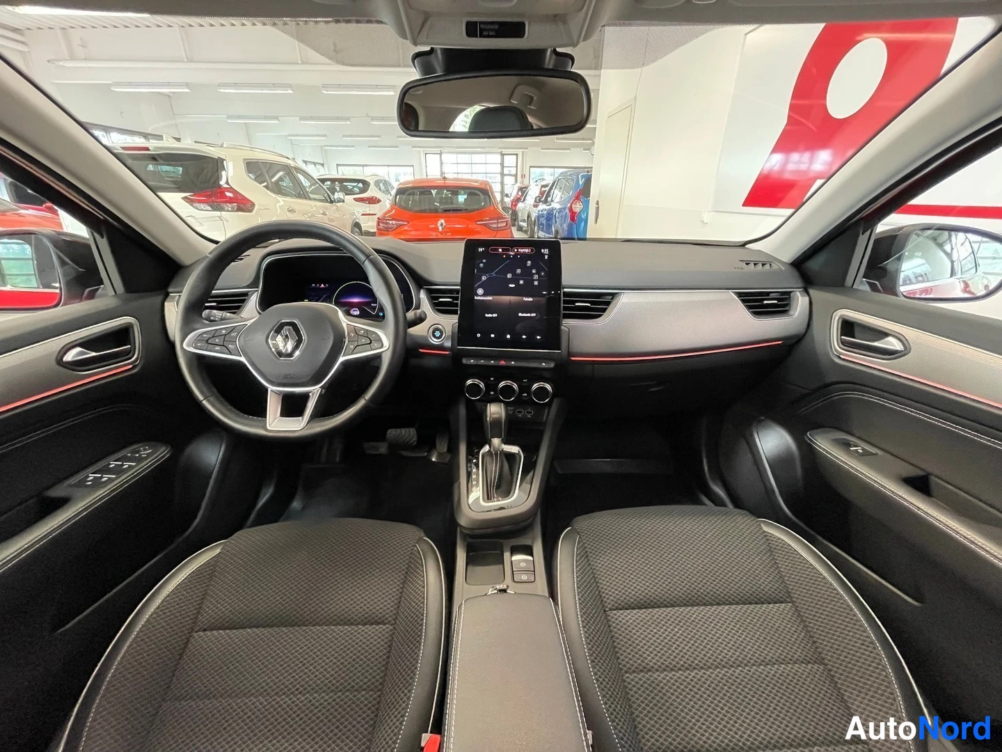 Muu: Sisätilakuva Renault-auton etuosasta: ohjauspyörä, mittaristo, keskikonsolin kosketusnäyttö ja kaksi etuistuinta.