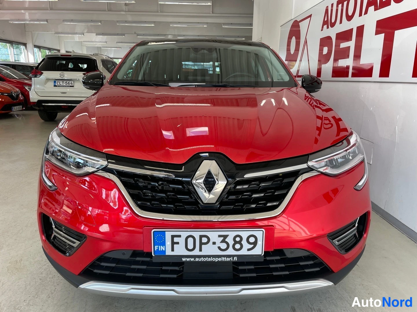 Edestä: Punaisen Renault Arkanan keulakuva keskeltä; rekisterikilpi ja Renault-logotunnus näkyvissä.