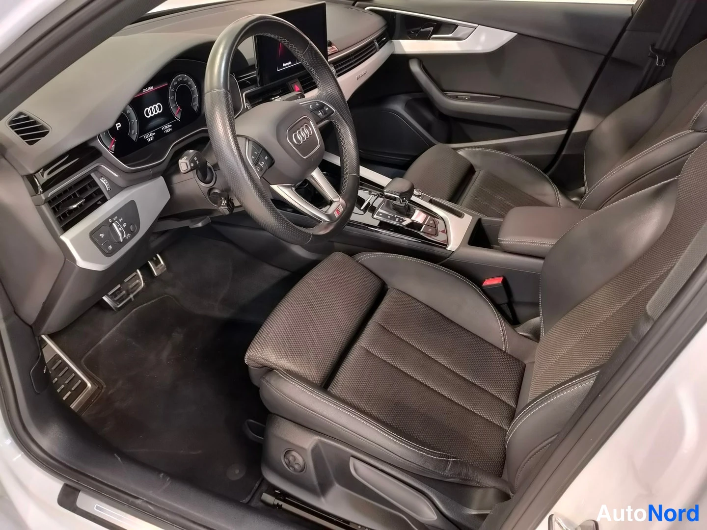 Muu: Auton sisätilat kuljettajan puolelta: musta nahkaverhoillut urheiluistuimet, Audi-ohjauspyörä ja keskikonsoli.