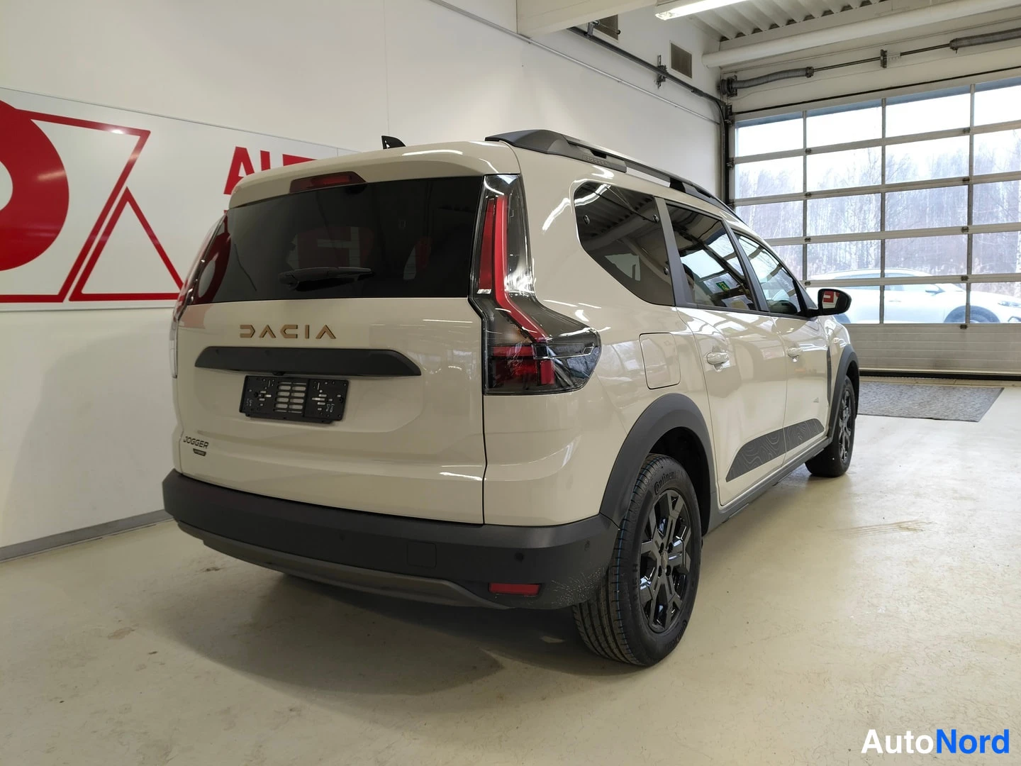 Takaviisto: Auto kolmivirnäisesti takaa vasemmalta: beige koripaneelit, kattokaiteet, mustat kevytmetallivanteet.