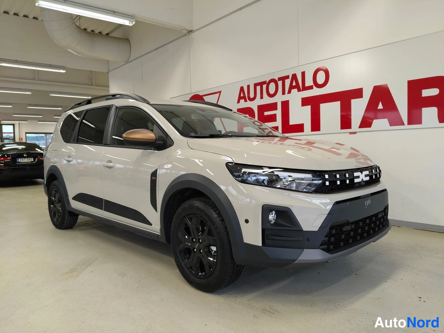 Etuviisto, nokka oikealle: Auto kolmivirnäisesti edestä oikealta: beige koripaneelit, mustat vanteet, kuparihohtoinen peilin kansi.