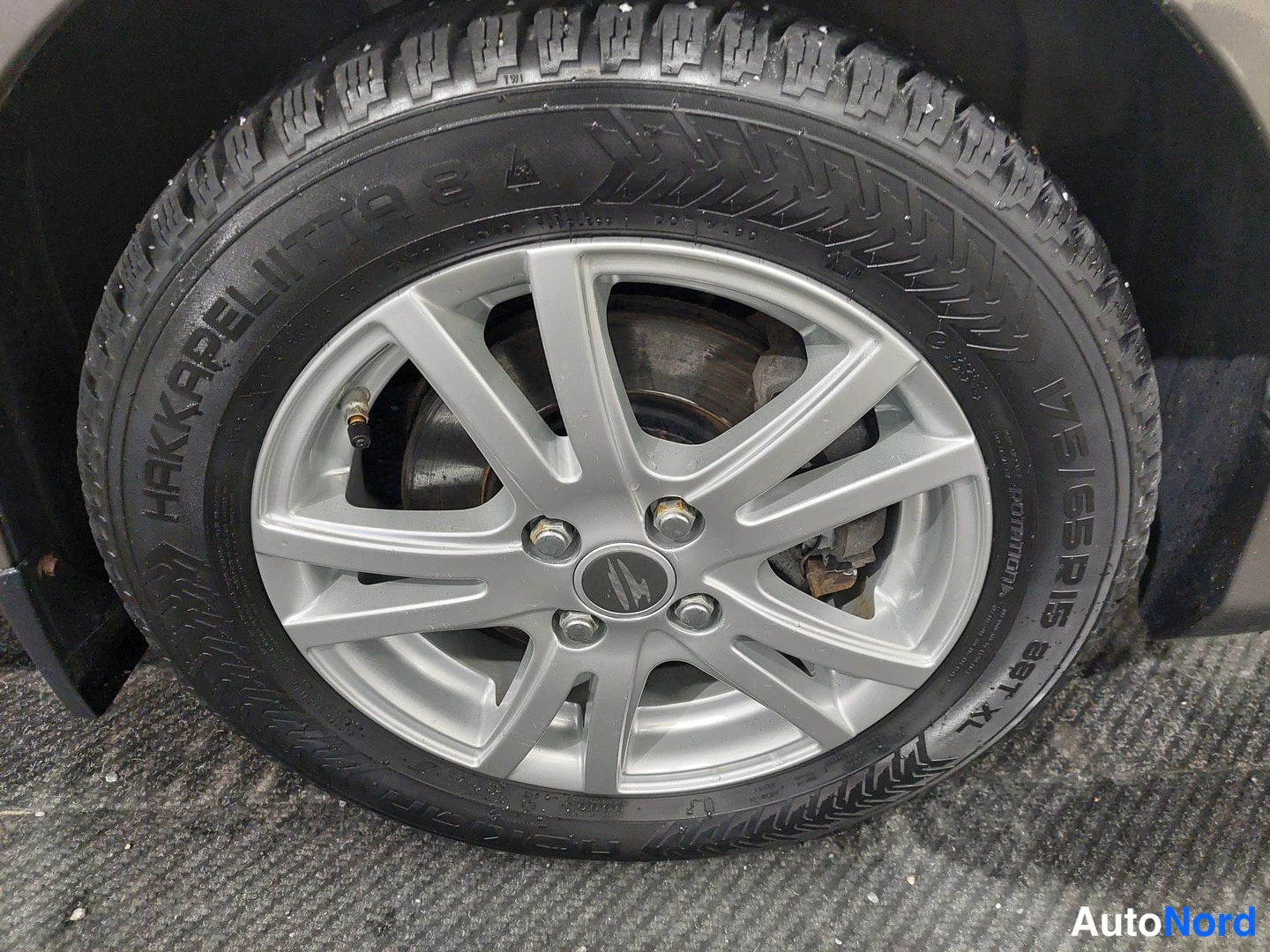 Yksityiskohta: Renkaan ja kevytmetallivanteen lähikuva: Nokian Hakkapeliitta 8 -talvirengas, kokoluokka 175/65 R 15 84T XL, hopeinen monisakarainen vanne ja jarrulevy näkyviss