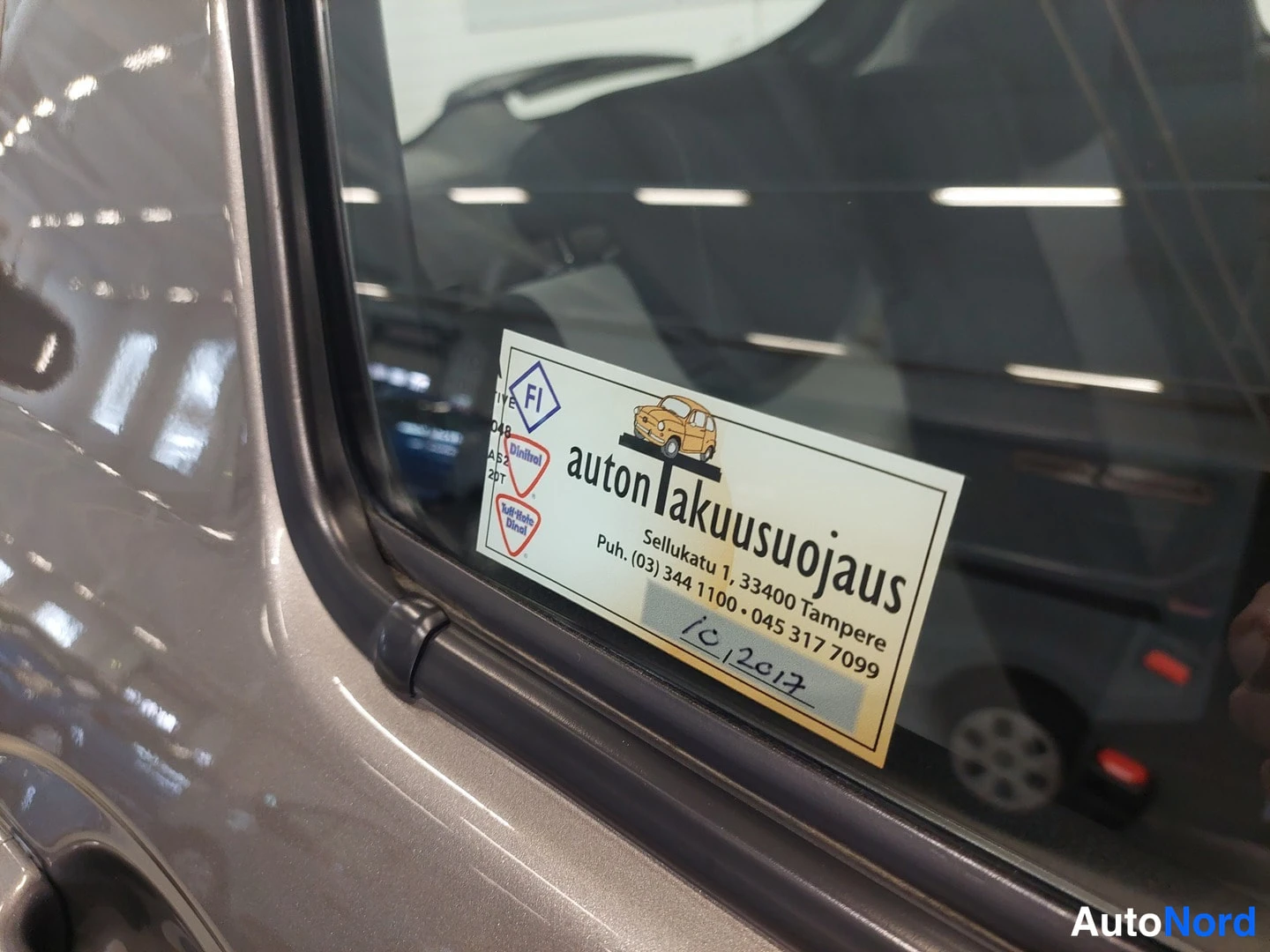 Yksityiskohta: Kulmassa näkyy autotakuujauksen tarru auton lasissa.