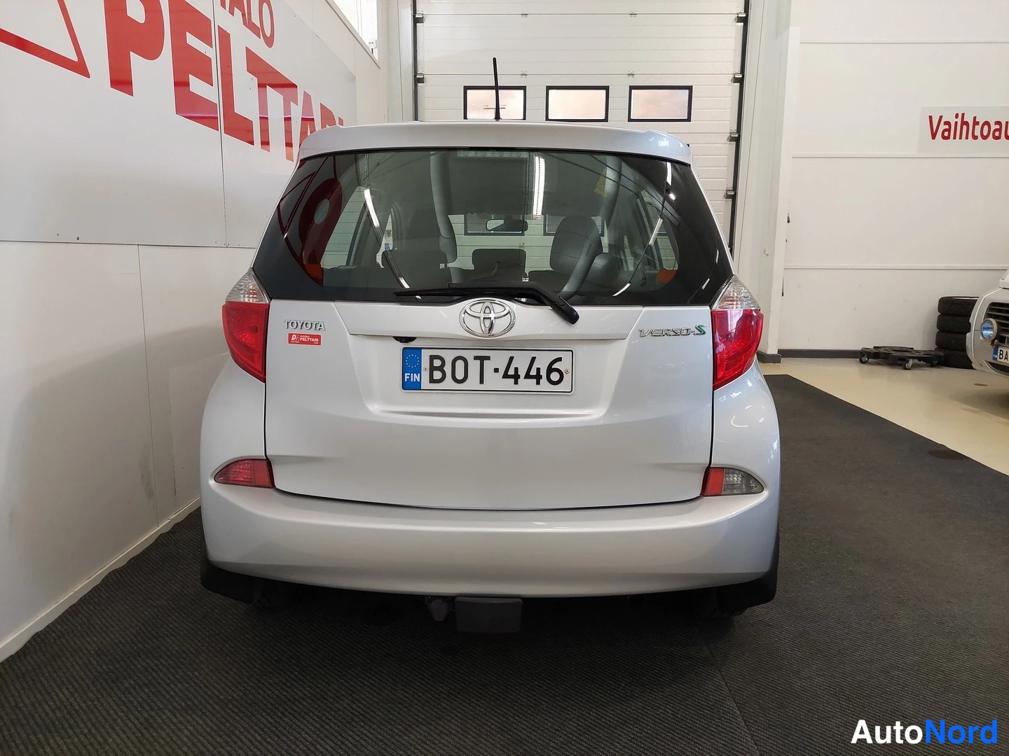 Takaa: Auton takapää suoraan takaa kuvattuna, Toyota-merkki, rekisterikilpi ja VERSO-S-teksti näkyvissä.
