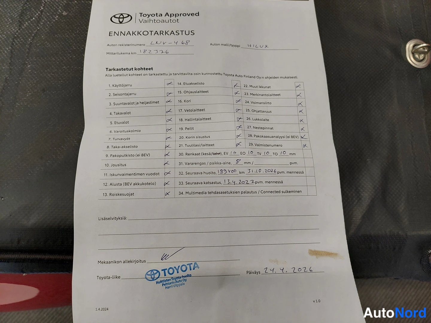 Muu: Toyota Approved -ennakkotarkastuslomake, jossa ruksitut tarkistuskohdat, rekisterinumero, malli HILUX, mittarilukema 182326 km sekä mekaanikon allekirjoitus ja