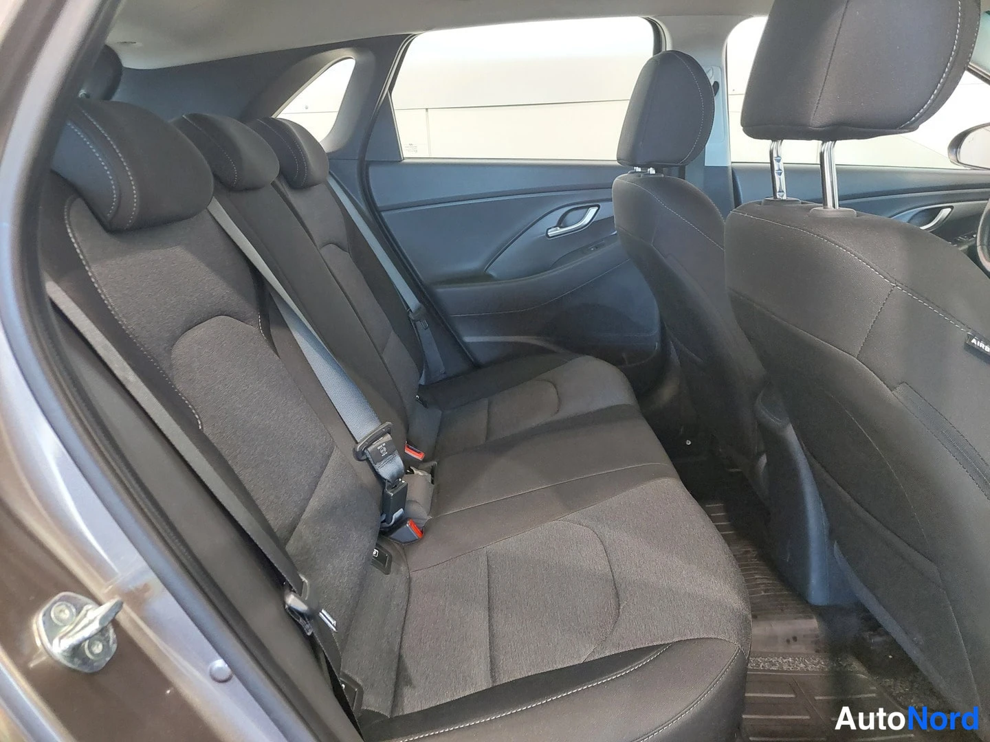 Muu: Hyundai i30:n takaistuimet tummasta kankaasta avatusta takaovesta kuvattuna.
