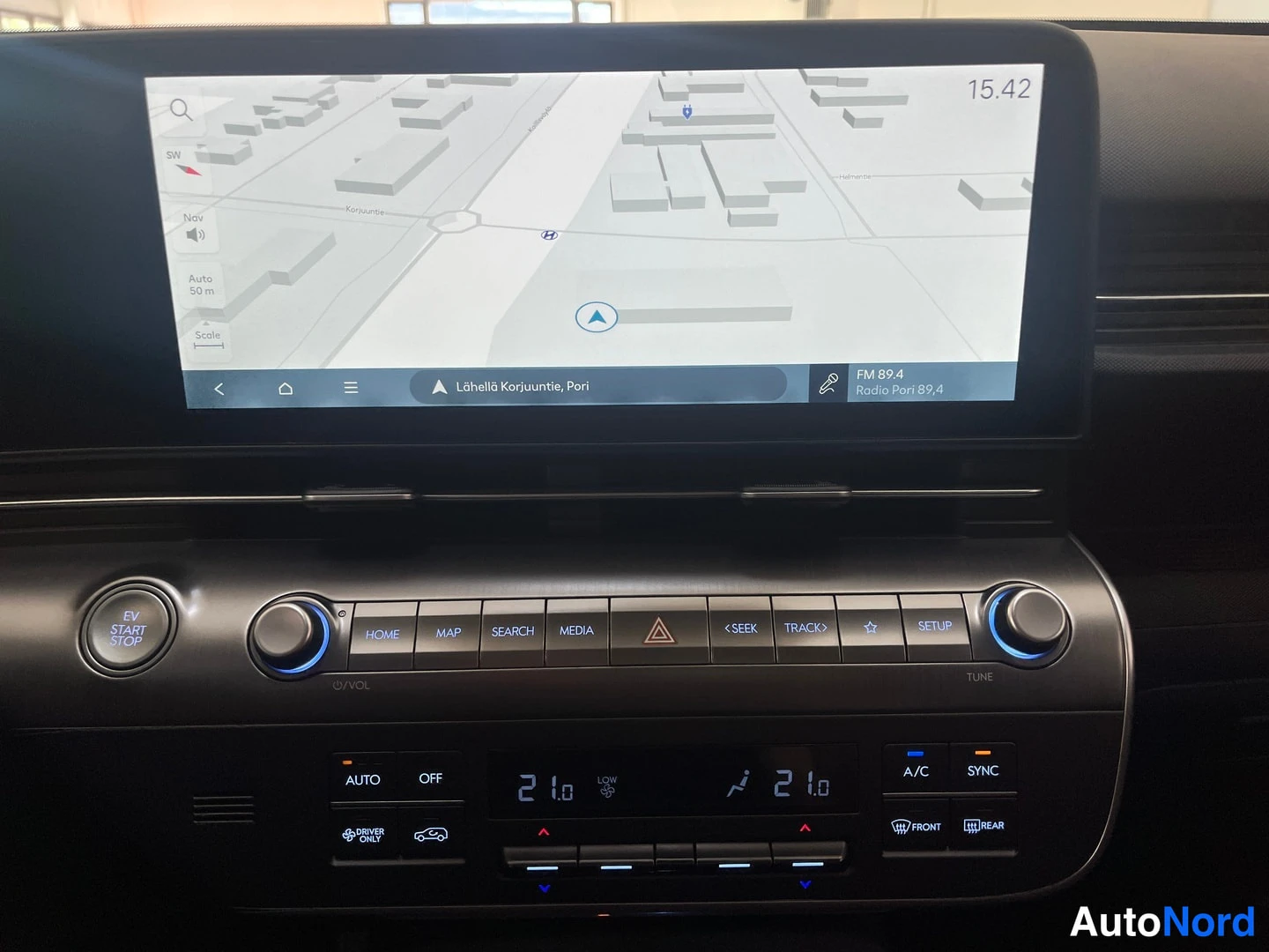 Muu: Infotainment-näytöllä navigaatiokartta ja FM-radio (Radio Pori 89,4), alla kosketusnapit, EV START STOP -nappi ja automaattisen ilmastoinnin paneeli.