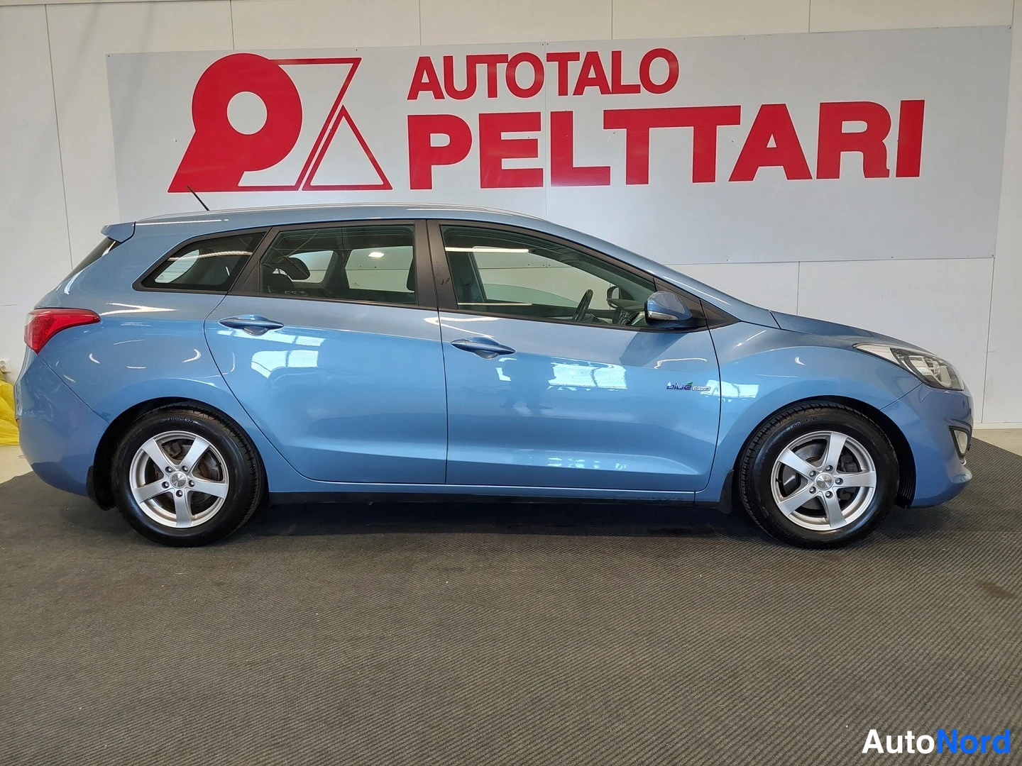 Sivulta: Sininen Hyundai i30 Farm sivusta vasemmalta, viisiovainen farmarikorinen auto näkyy kokonaan.