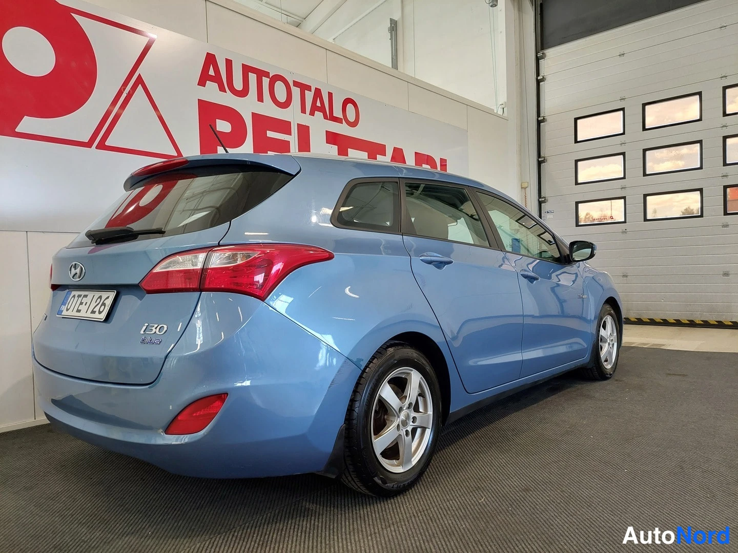 Takaviisto: Sininen Hyundai i30 Farm takaa viistosti oikealta, rekisterikilpi.
