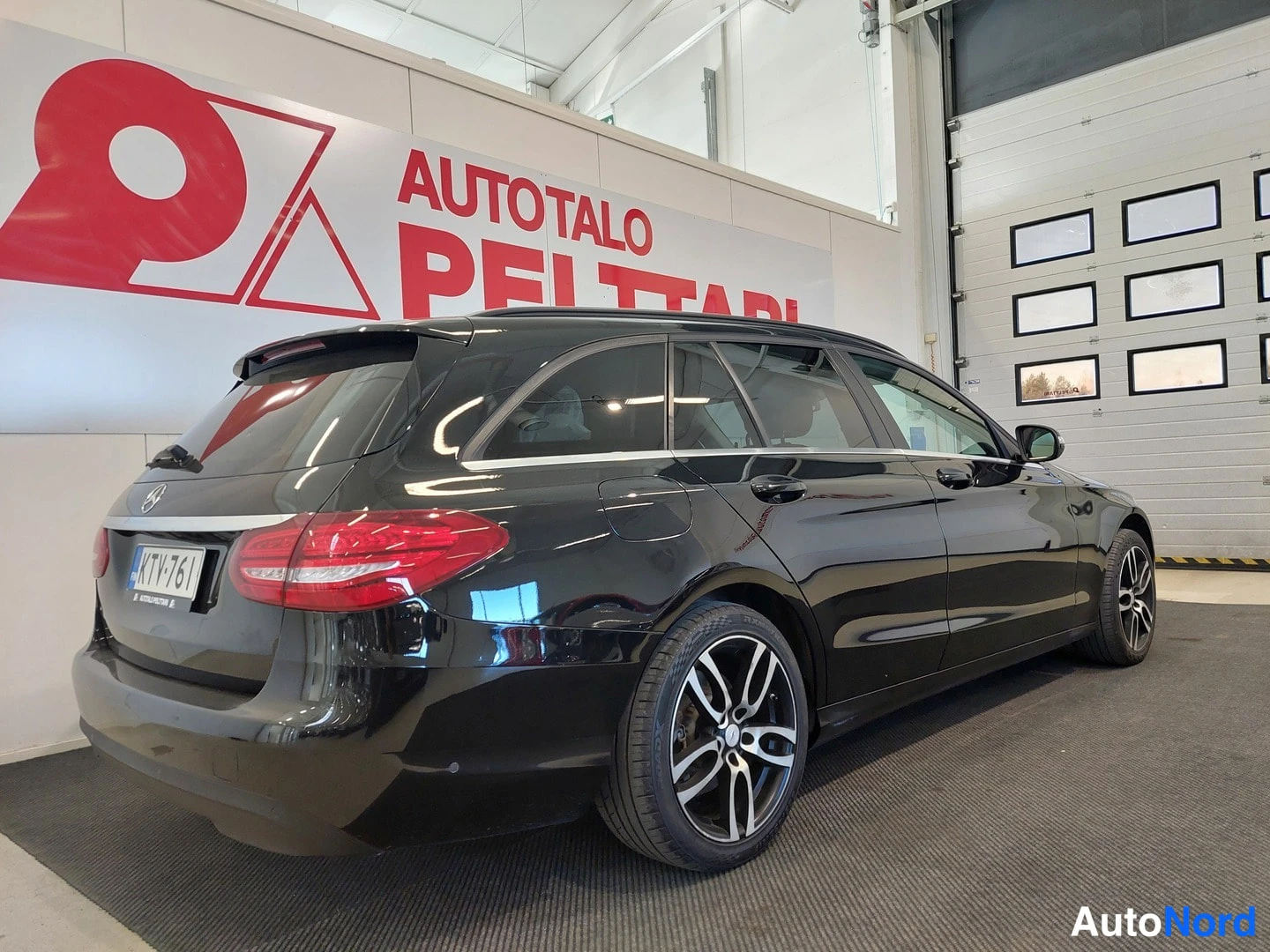 Takaviisto: Musta Mercedes-Benz C-sarjan farmari takaa oikeasta kulmasta, punaiset takavalot, rekisterikilpi, kevytmetallivanteet.