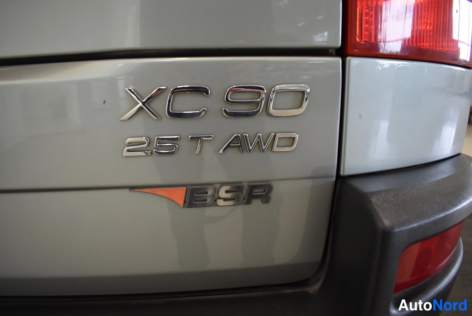Muu: Lähikuva XC90 2.5 T AWD -merkinnöistä ja BSR-tunnuksesta peräluukussa.