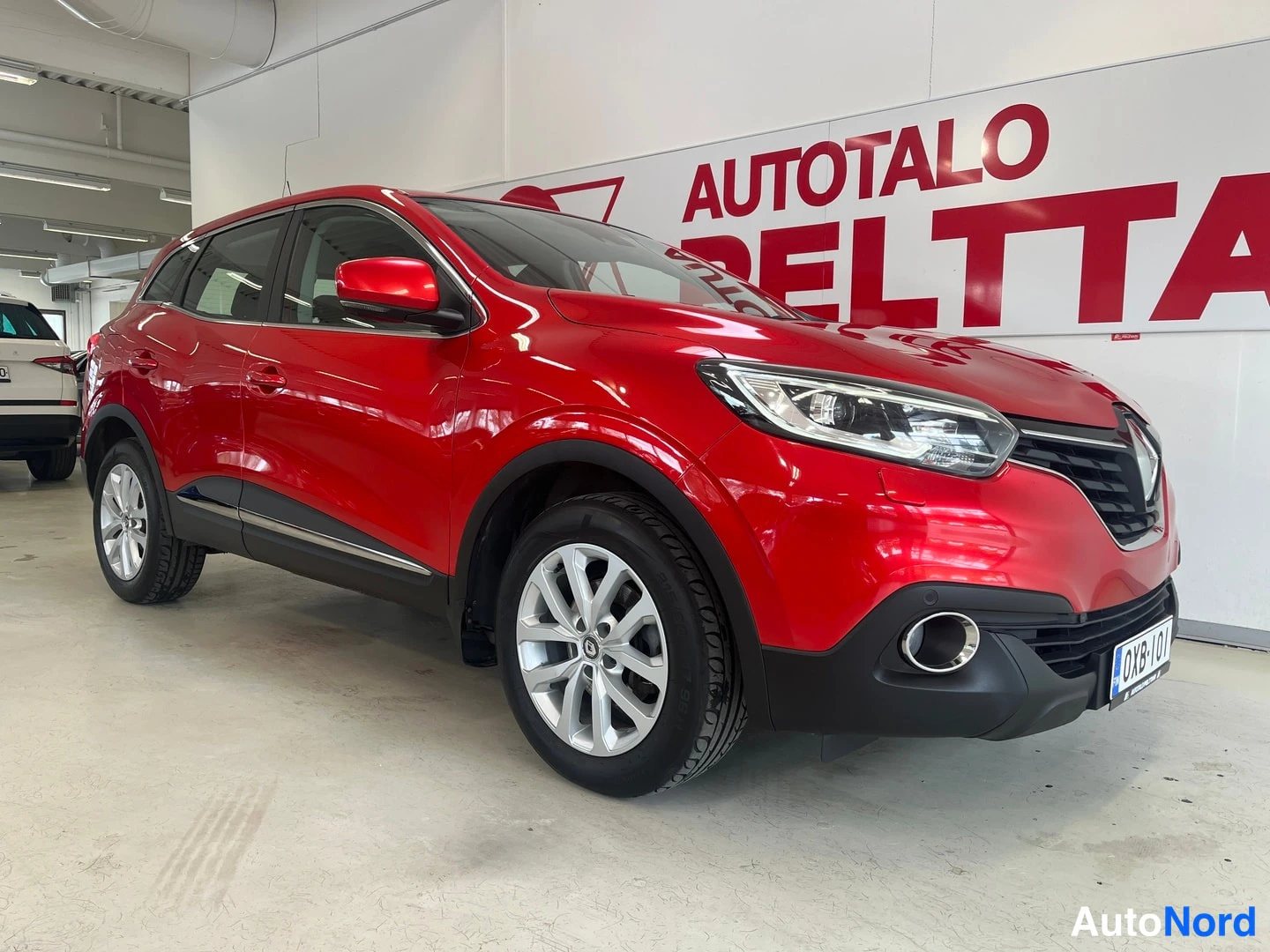 Etuviisto, nokka oikealle: Punaisen Renault Kadjarin etukulma oikealta nähtynä.