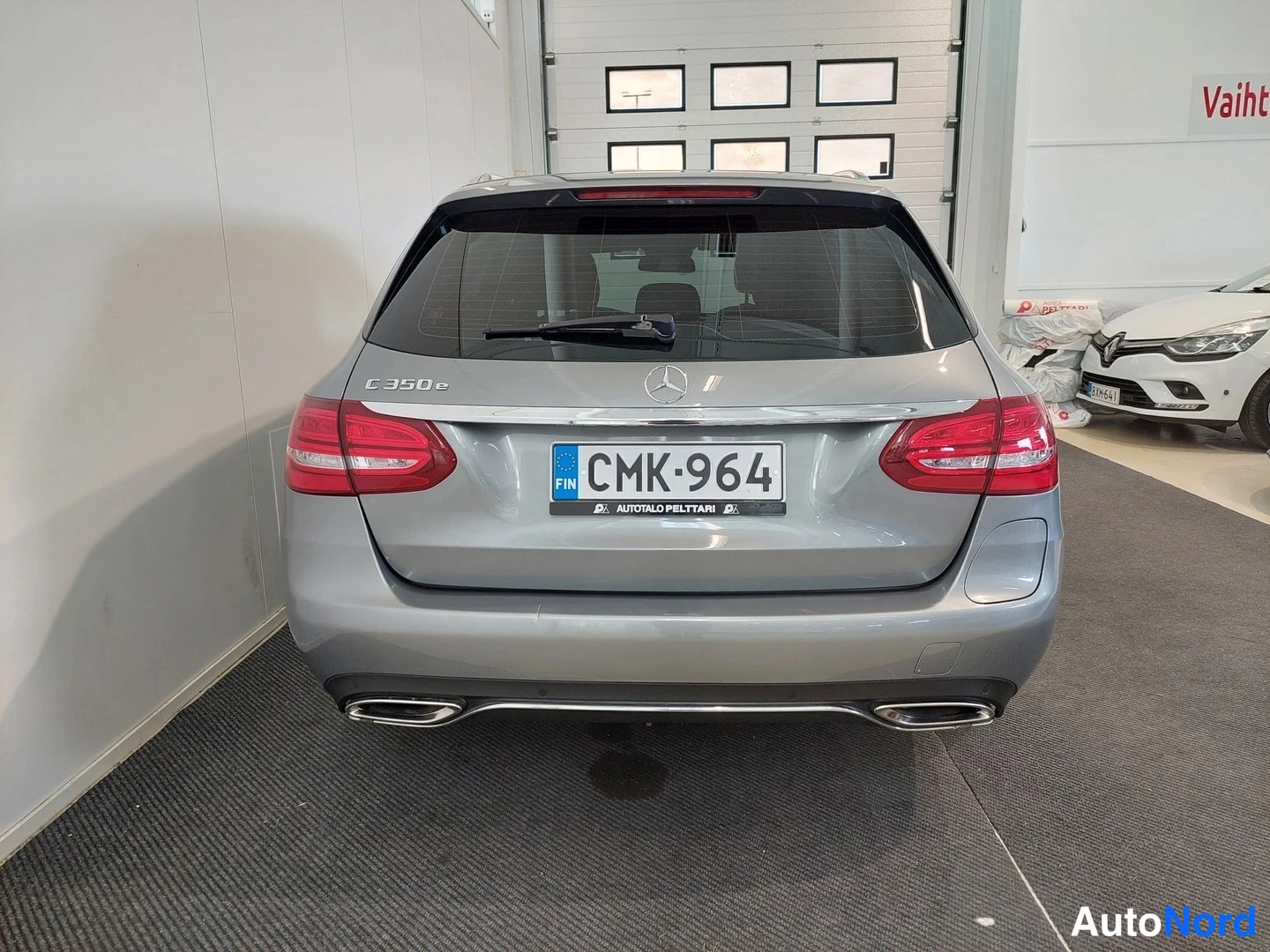 Takaa: Mercedes-Benz C 350e -farmarin takaosa takaa päin; pellillä C 350 e -teksti, rekisteri, hopeanharmaa kori ja kaksi pakoputkea.