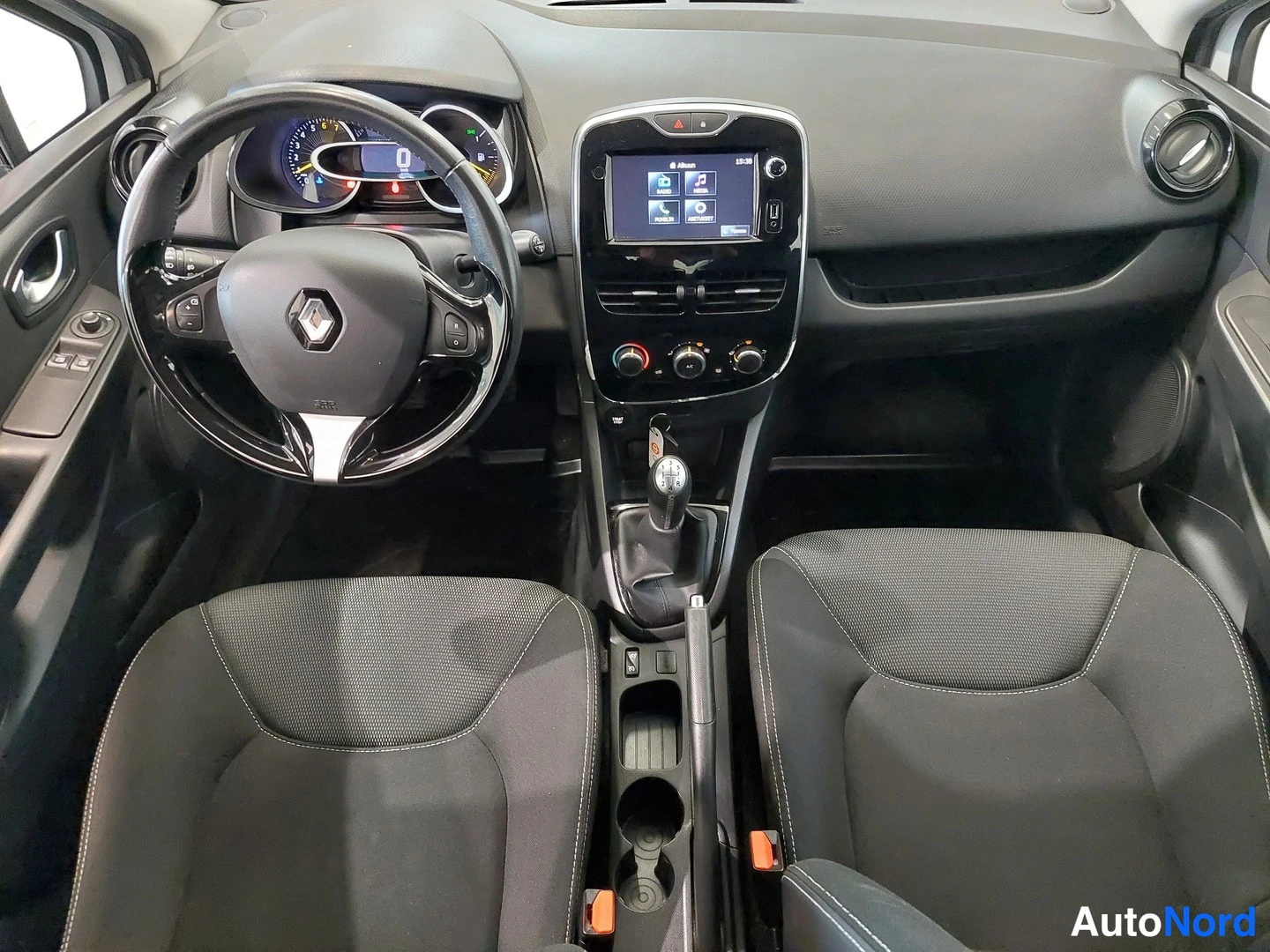 Muu: Auton ohjaamo näkyvissä eteenpäin: tumma kojelauta, Renault-ohjauspyörä, kosketusnäyttö ja kaksi etuistuinta.