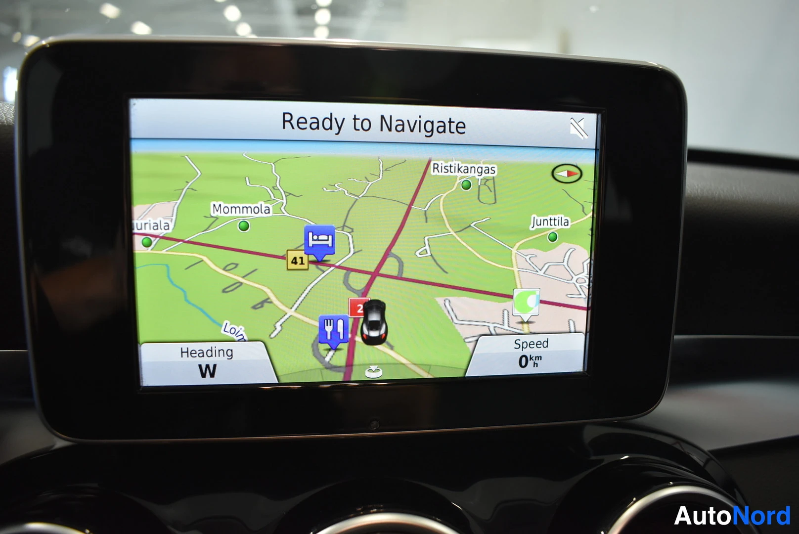 Yksityiskohta: Infotainment-näyttö, jossa navigaatiokartta ja teksti Ready to Navigate.