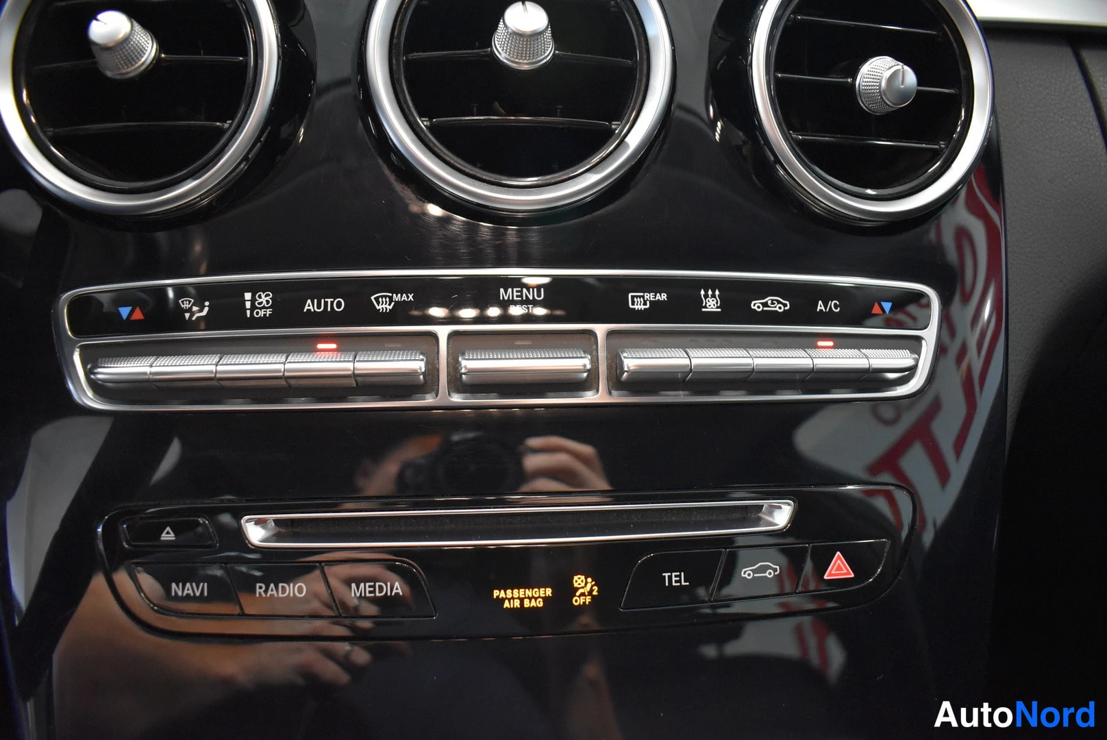 Yksityiskohta: Kojelaudan keskusrivin painikkeet AUTO, MENU, REAR ja A/C sekä NAVI, RADIO, MEDIA ja TEL.
