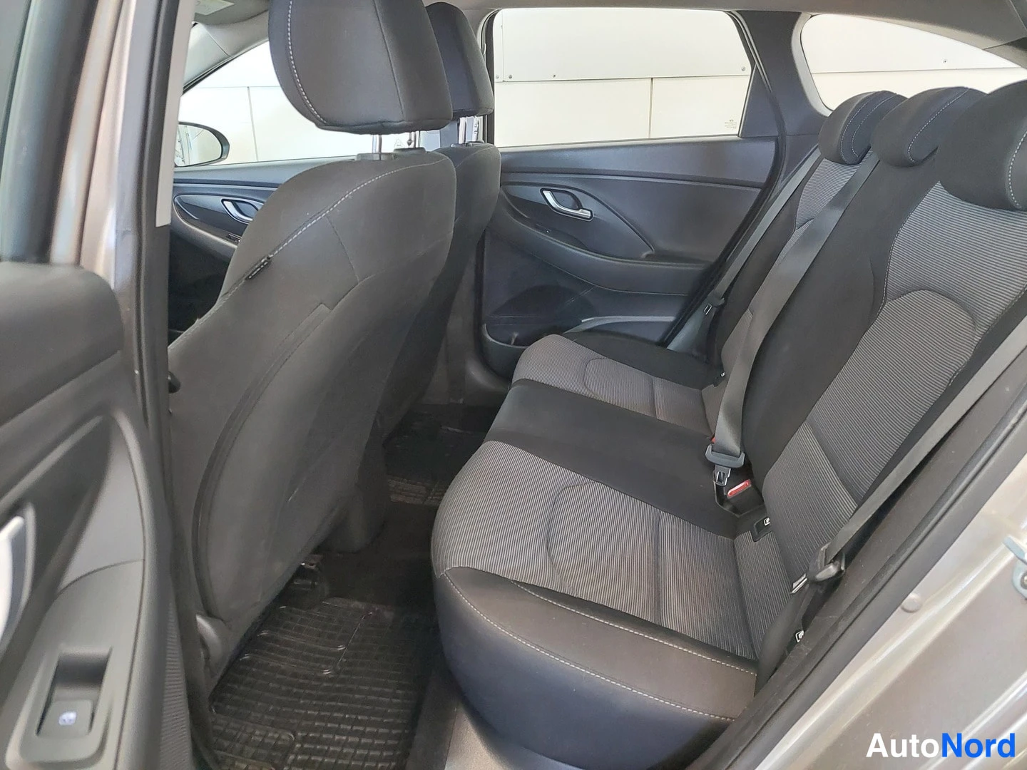 Muu: Takapenkiltä kuvattu Hyundai i30 Farmrin takaosa: kankainen takaistuin ja istuinten pääntuet, takiovi auki ja matot lattialla.
