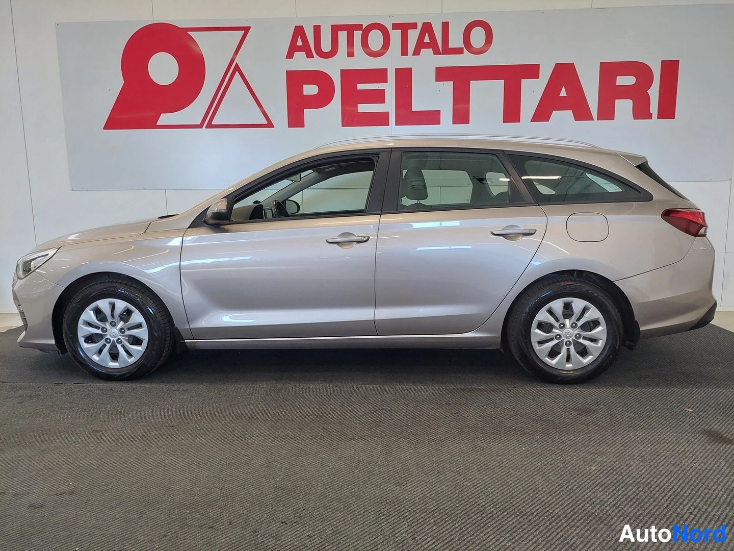 Takaviisto: Hyundai i30 -farmari sivulta oikealta kuvattuna; vaaleanbeige runko, koko kori näkyvissä.
