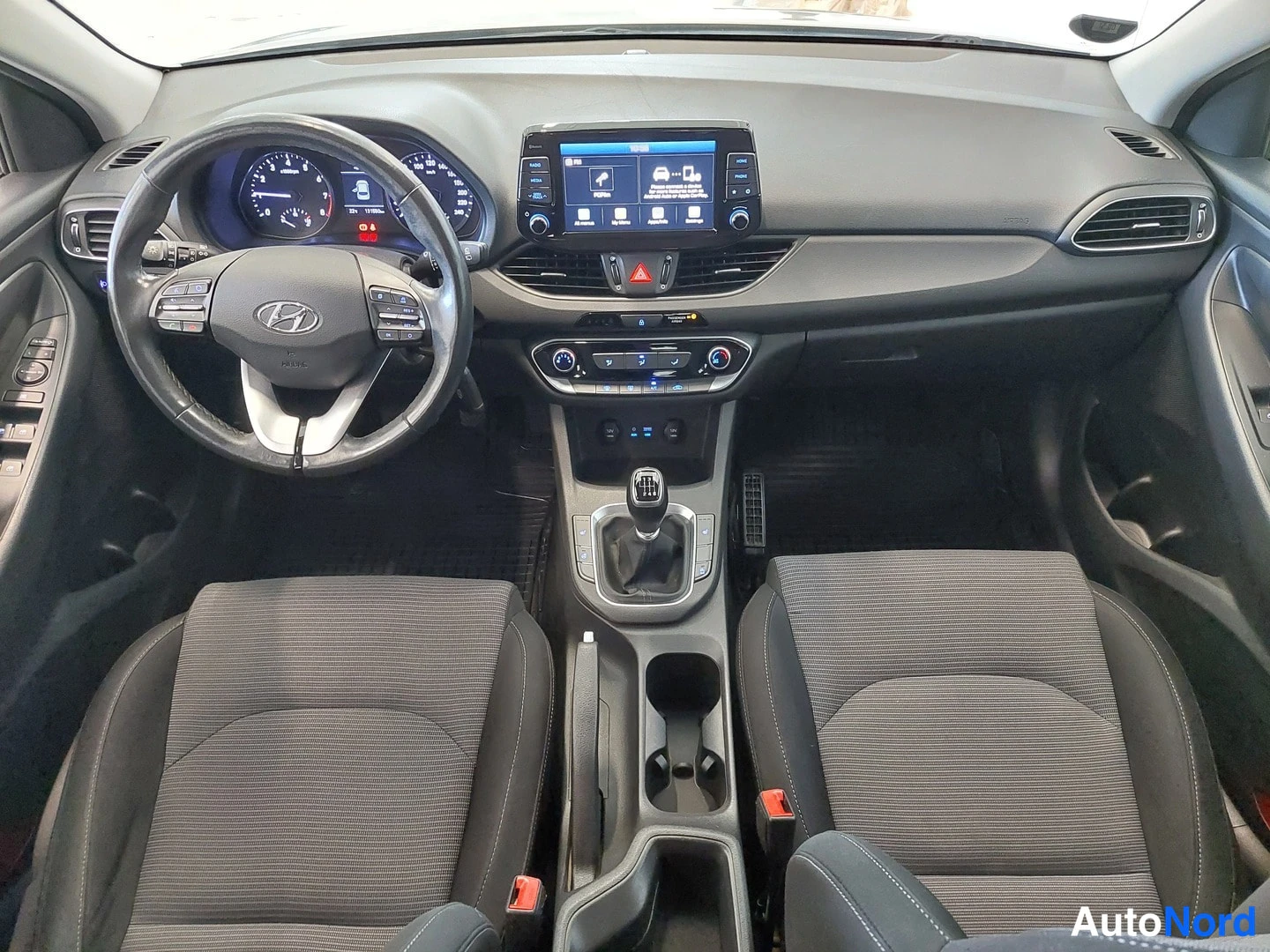 Muu: Hyundai i30 interior from above: dashboard, steering wheel, touchscreen infotainment, manual gear lever and two front seats.