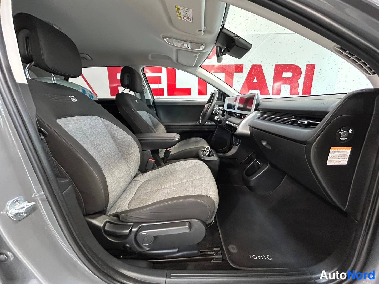 Muu: Hyundai IONIQ 5:n sisätila kuljettajan ovesta katsottuna, etuistuimet ja mittariston näytöt