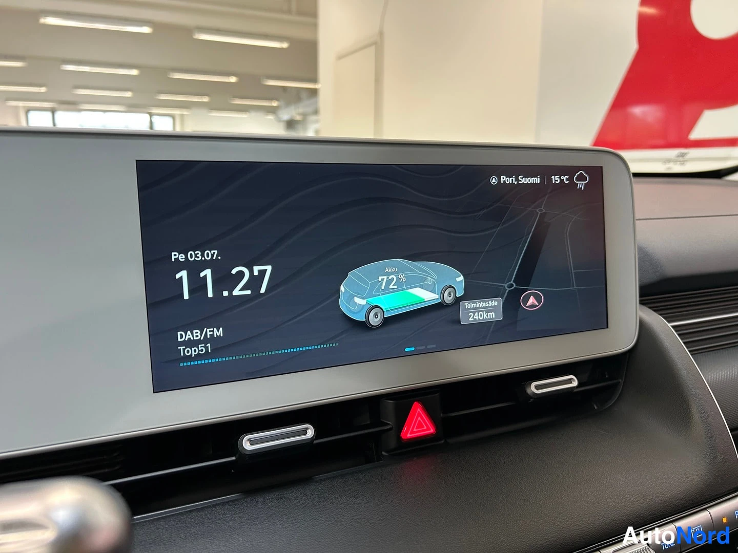 Muu: Infotainment-näyttö näyttää sähköauton akun varaustilaa 72 % ja toimintasädettä 240 km, kellonaika 11.27.