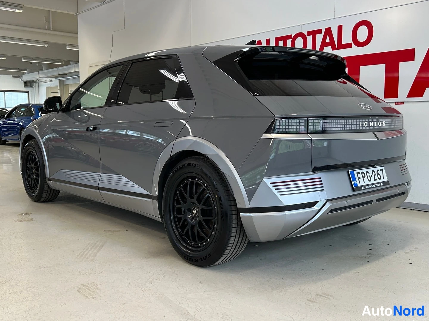 Takaviisto: Harmaa Hyundai IONIQ 5 takaviistosta oikealta, IONIQ 5 -teksti takavalossa, rekisteritunnus.