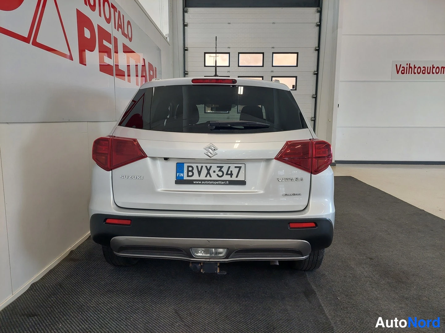 Takaa: Auton takaosa suoraan takaa: rekisterikilpi, Suzuki-merkki ja takaletkut.