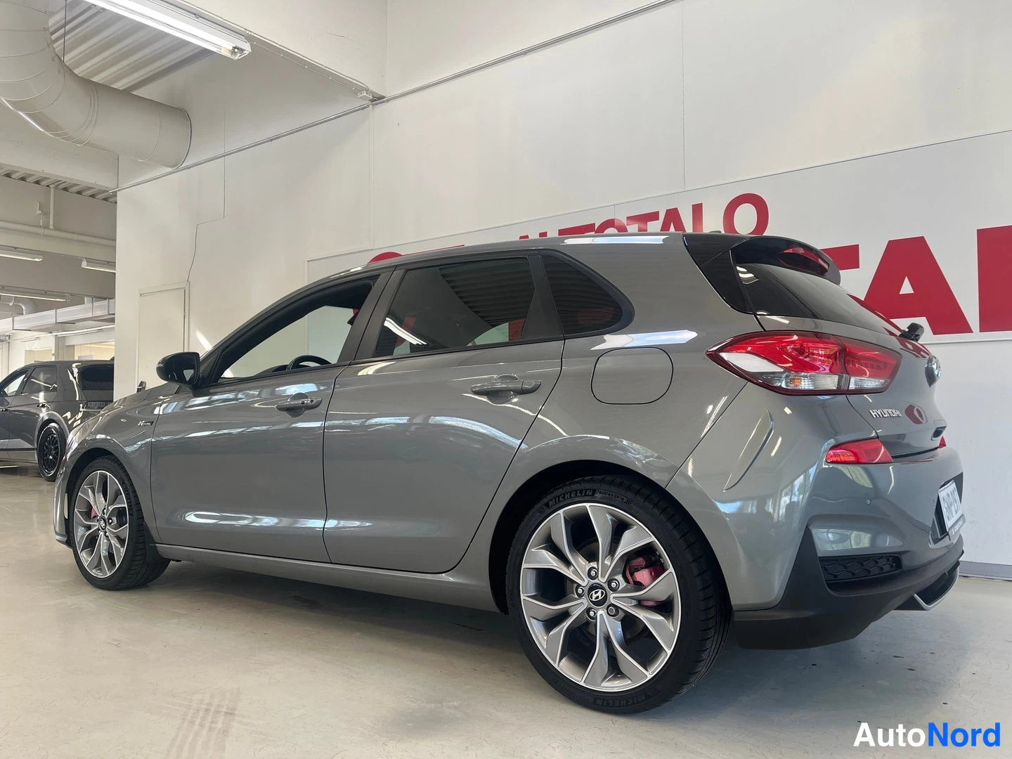 Takaviisto: Hyundai i30 -viistoperä takaa sivulta katsottuna, harmaa koripinta ja viistoperän takaosa.
