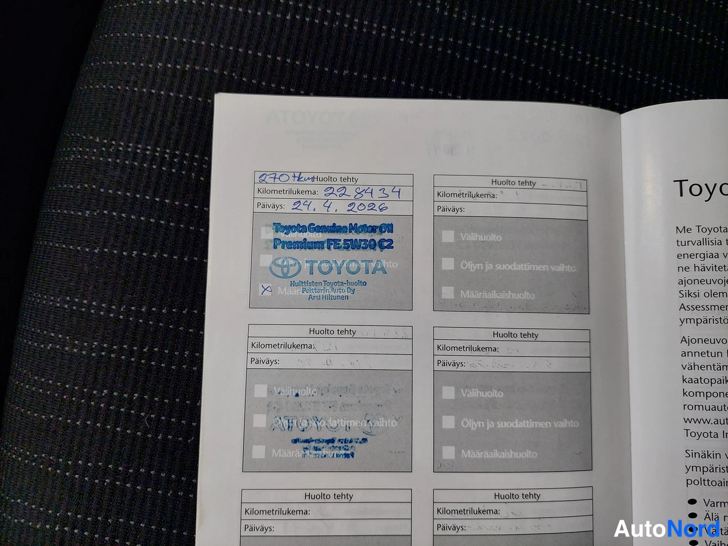 Yksityiskohta: Huoltokirjan sivu, jossa ylärivin huoltomerkintä: kilometrilukema 228 434, päiväys 24.4.2026, Toyota Genuine Motor Oil Premium FE 5W30 C2 -leima