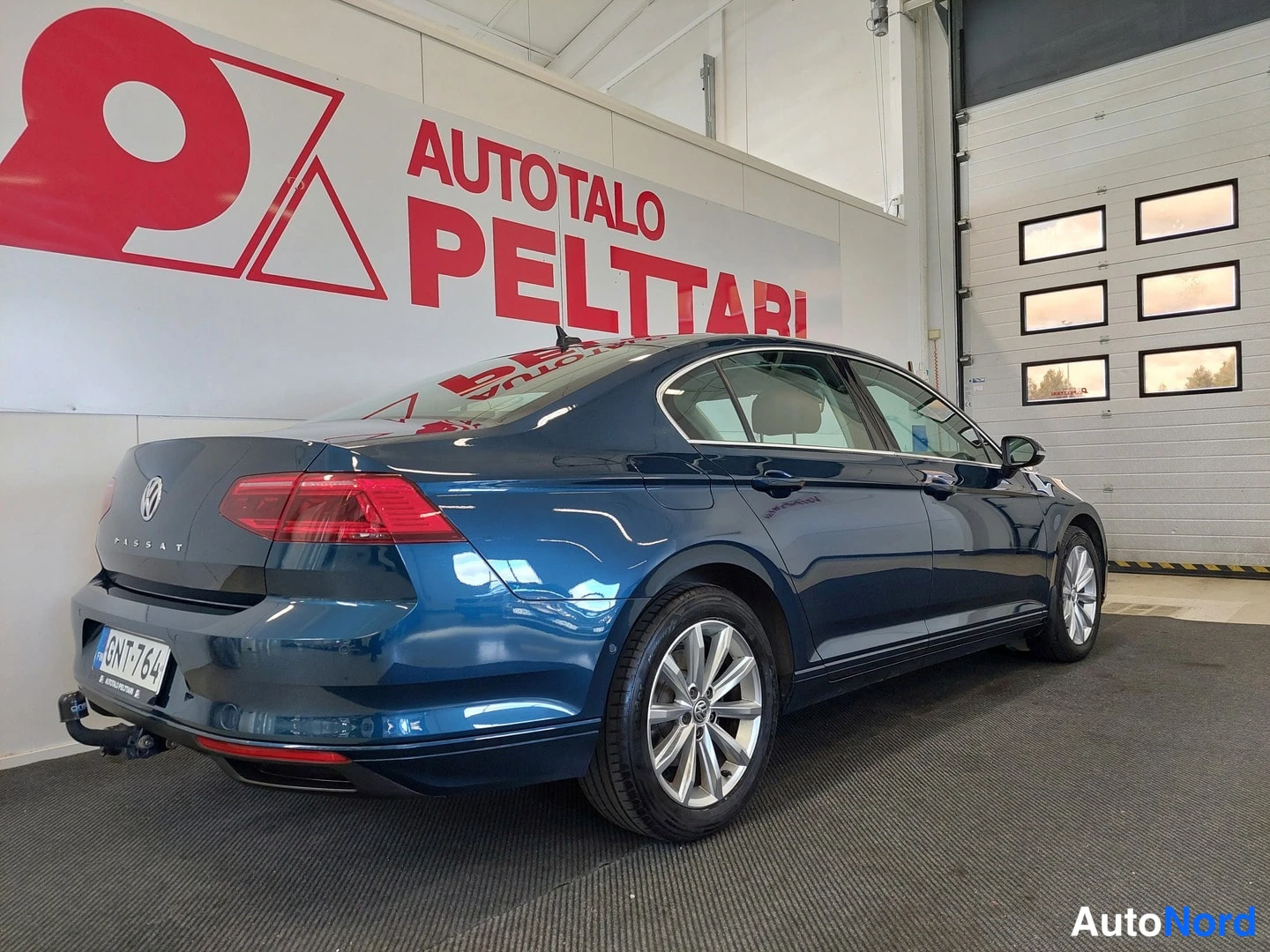 Takaviisto: Auton takakulma vasemmalta: tummansininen Volkswagen Passat -sedan, rekisterikilpi, vetokoukku näkyvissä.