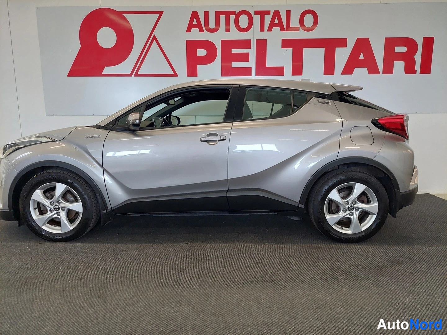 Sivulta: Toyota C-HR -auton sivunäkymä; kylkiviiva, hatchback-mallin katto ja takavalojen reunat näkyvät sisätiloissa.