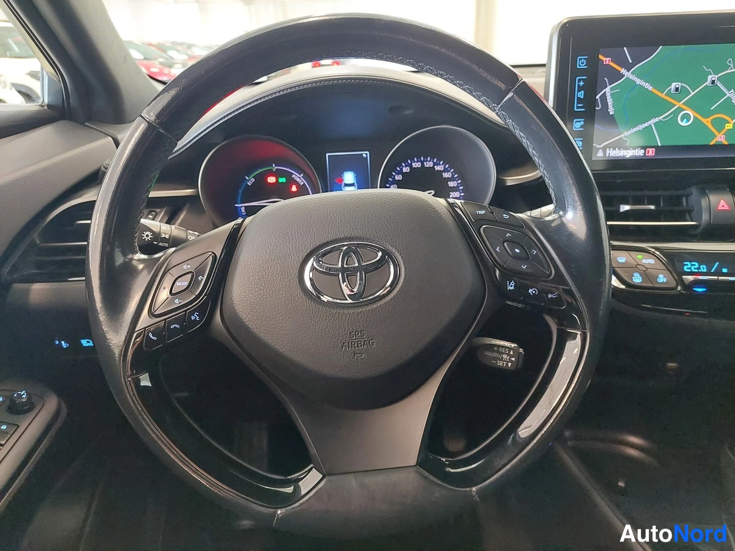 Muu: Toyota-merkkinen ohjauspyörä, mittaristo ja osa kojelaudan infotainment-näytöstä, jolla näkyy kartta.