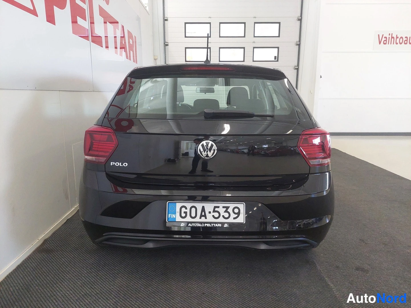 Takaa: Mustan Volkswagen Polo -matkailuauton takanäkymä, rekisteritunnus.