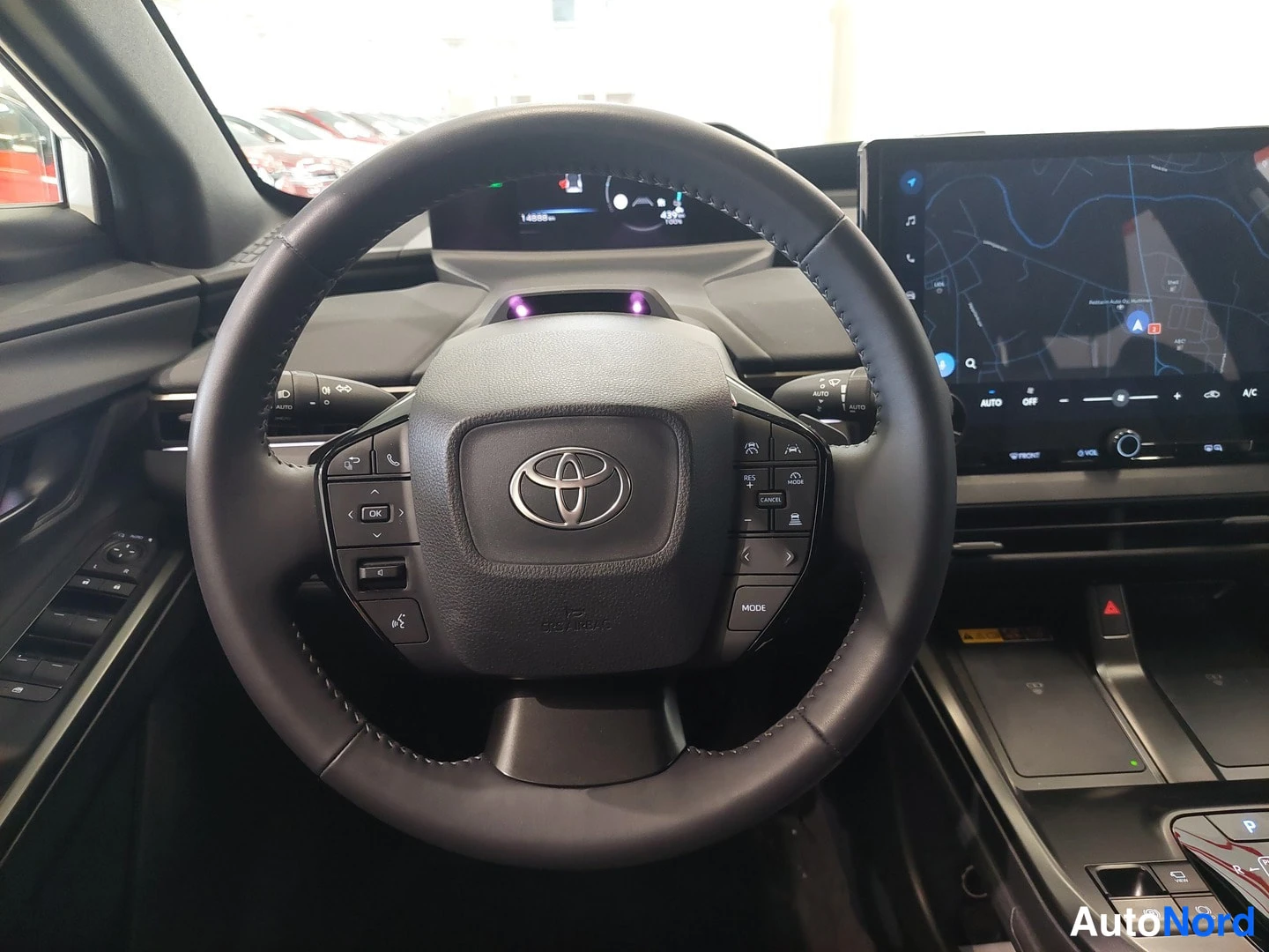 Muu: Toyota-merkillinen ohjauspyörä, kilometritaulun ja karttaanavigoinnin näyttävä infotainment-ruutu näkyvät taustalla.