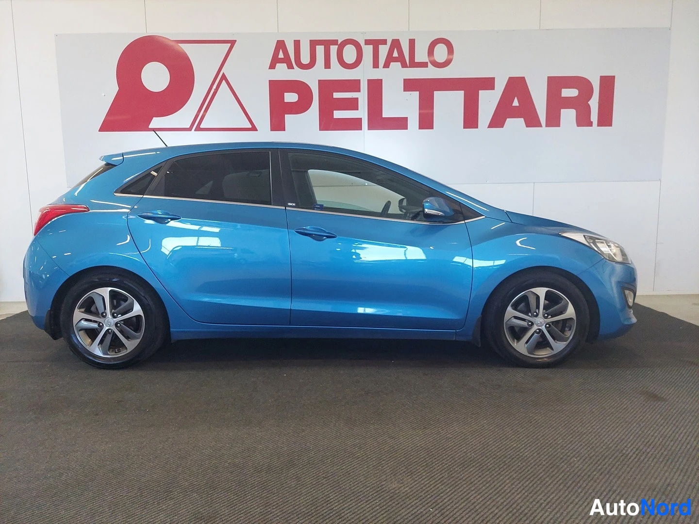 Etuviisto, nokka oikealle: Sininen Hyundai i30 etuviistosta oikealle, keula ja oikea sivu näkyvissä.