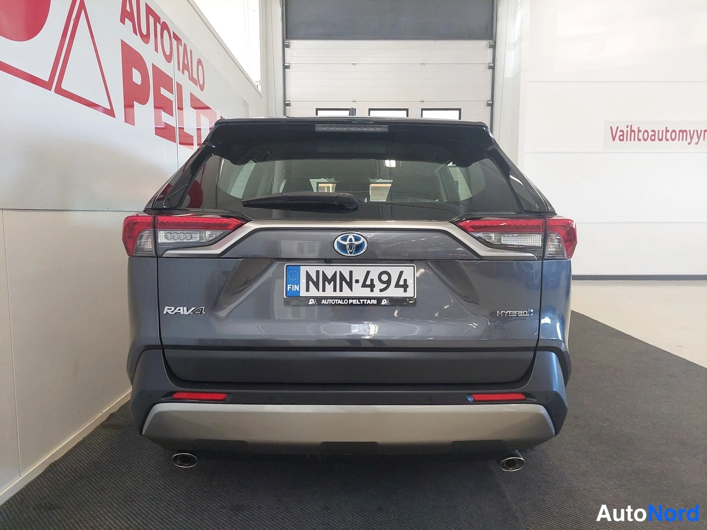 Takaa: Toyota RAV4 Hybridin takaosa, rekisteritunnus, Hybrid-takamerkki ja pyörrekaasut.