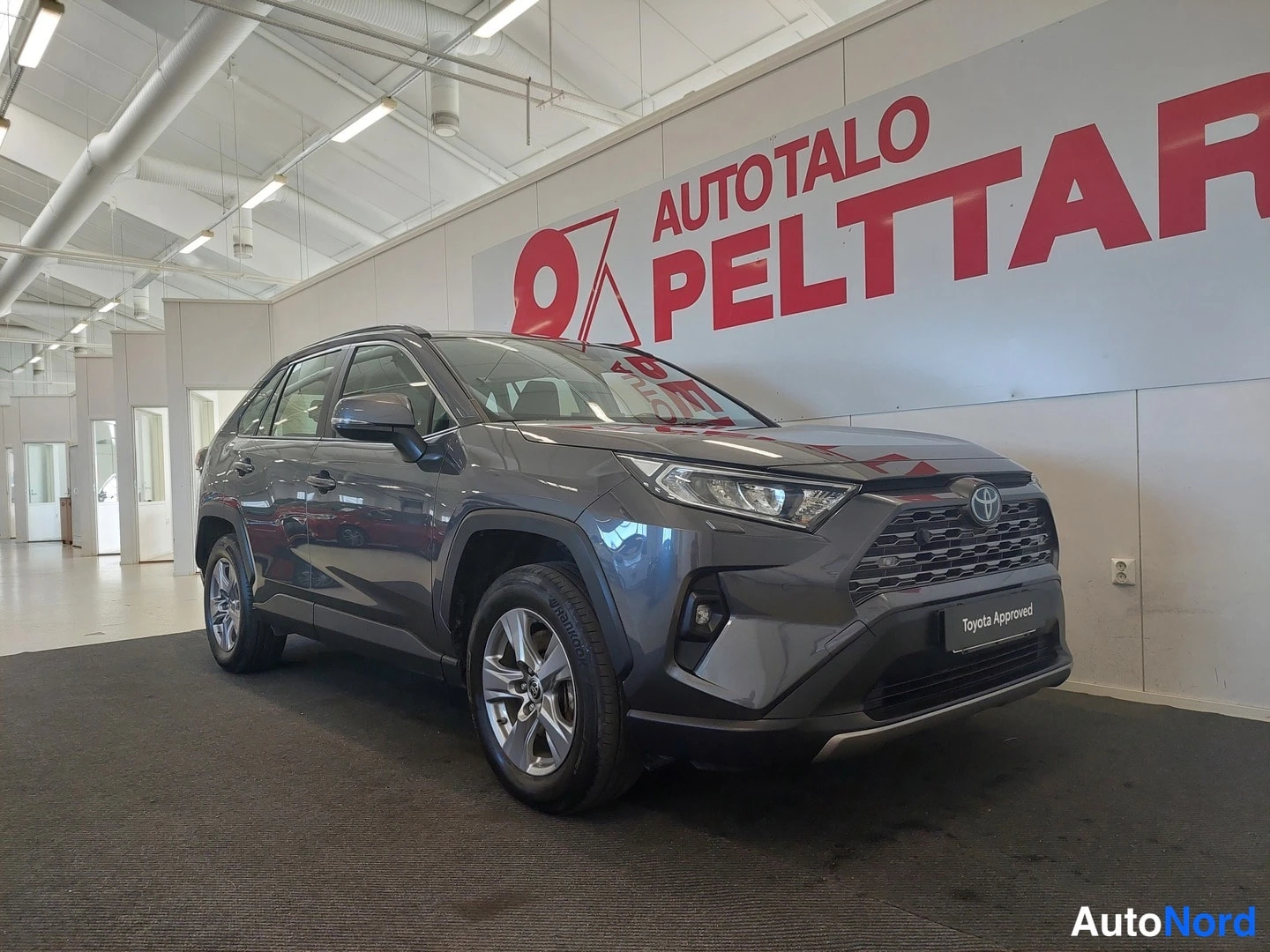 Etuviisto, nokka oikealle: Toyota RAV4:n etukolmanneksen kuva sisätiloissa, keulakontra and kylki näkyvät, keula oikealla, etukonepelti ja etuteleja näkyvät.