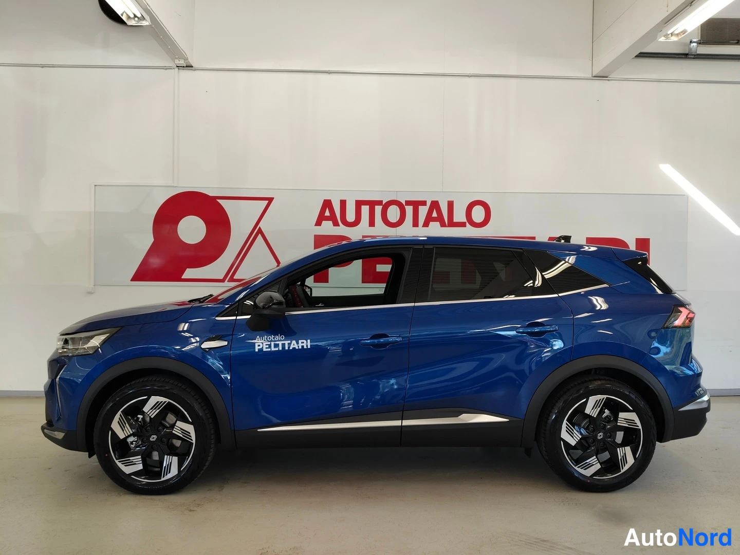 Sivulta: Sininen Renault Symbiozin vasen sivuprofiili sisätiloissa