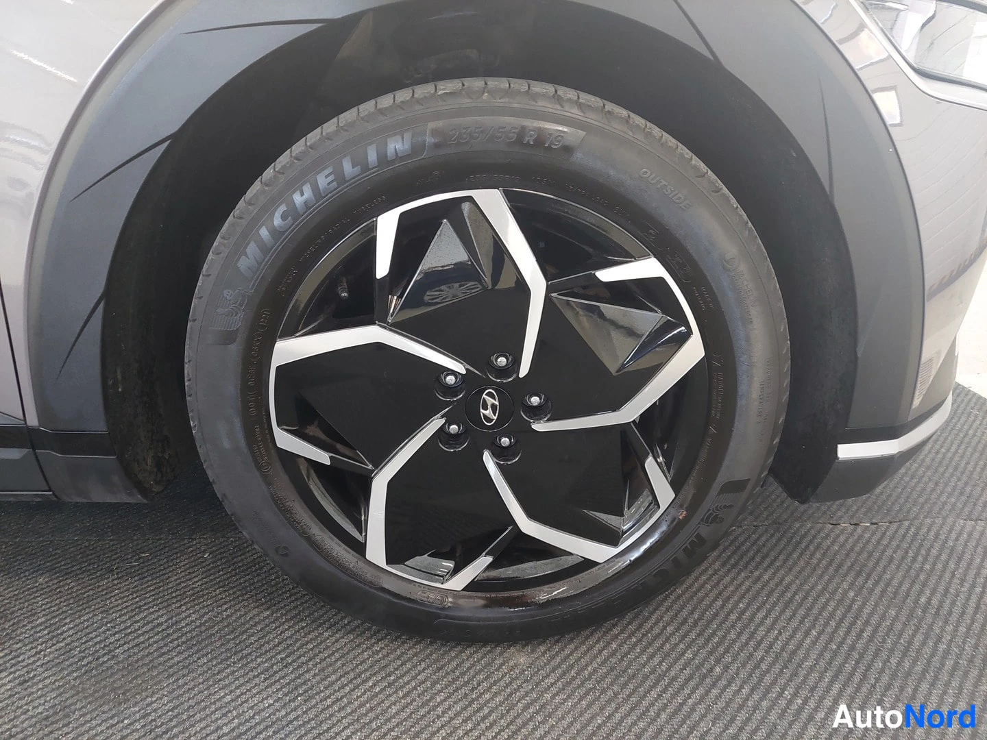 Muu: Michelin-renkaan lähikuva, vanteessa Hyundai-logo; rengaskoko 235/55 R19.