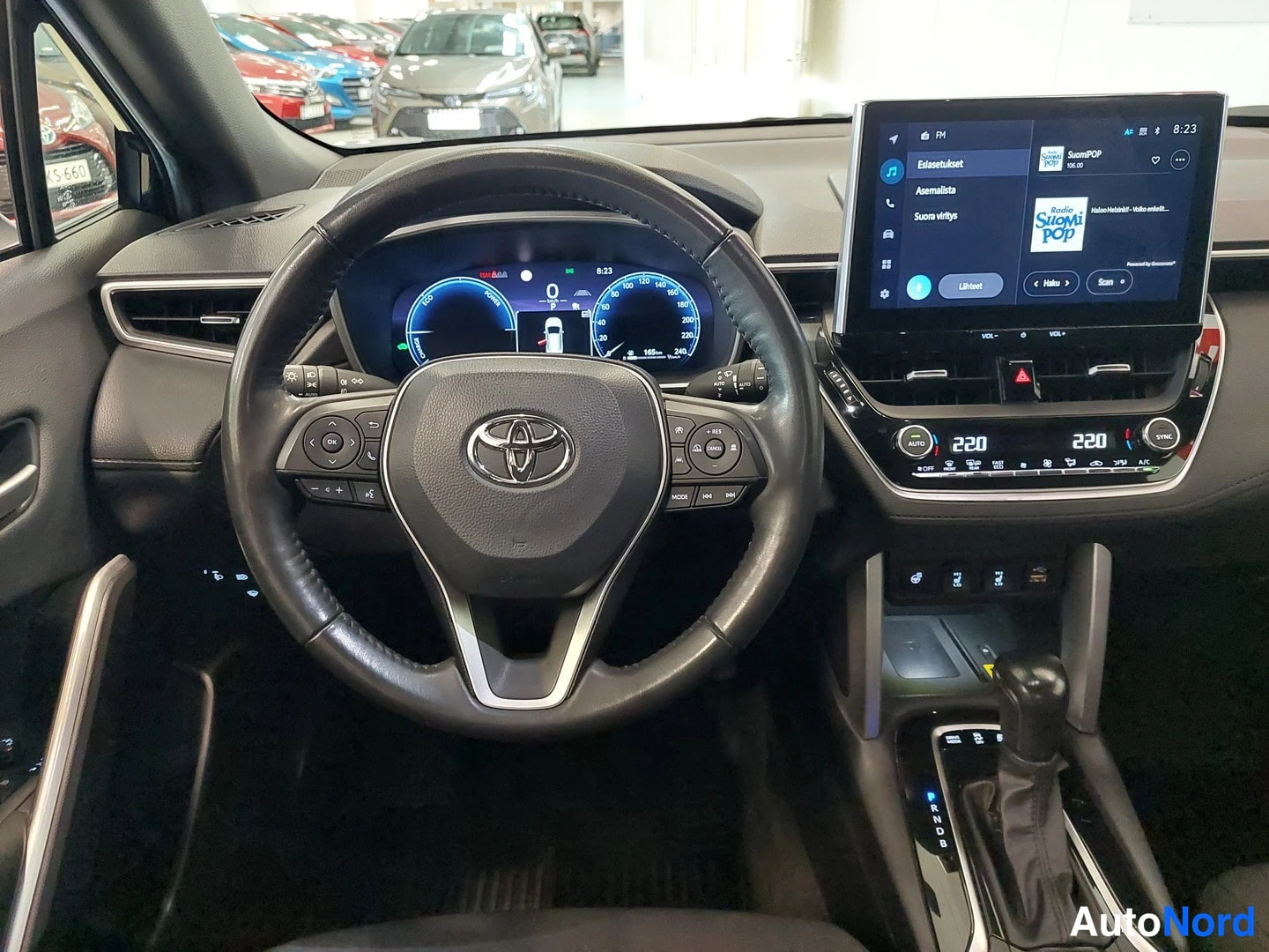 Muu: Ulostapäin näkymä kuljettajan paikalta; Toyota-ohjauspyörä, mittaristo ja infotainment-näyttö.