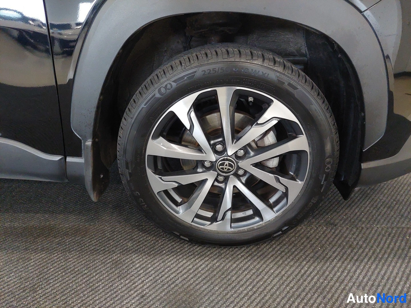 Muu: Ajon pyörä lähikuvassa: kaksivärinen Toyota-vanne ja renkaan sivuseinässä lukee 225/50 R 19.