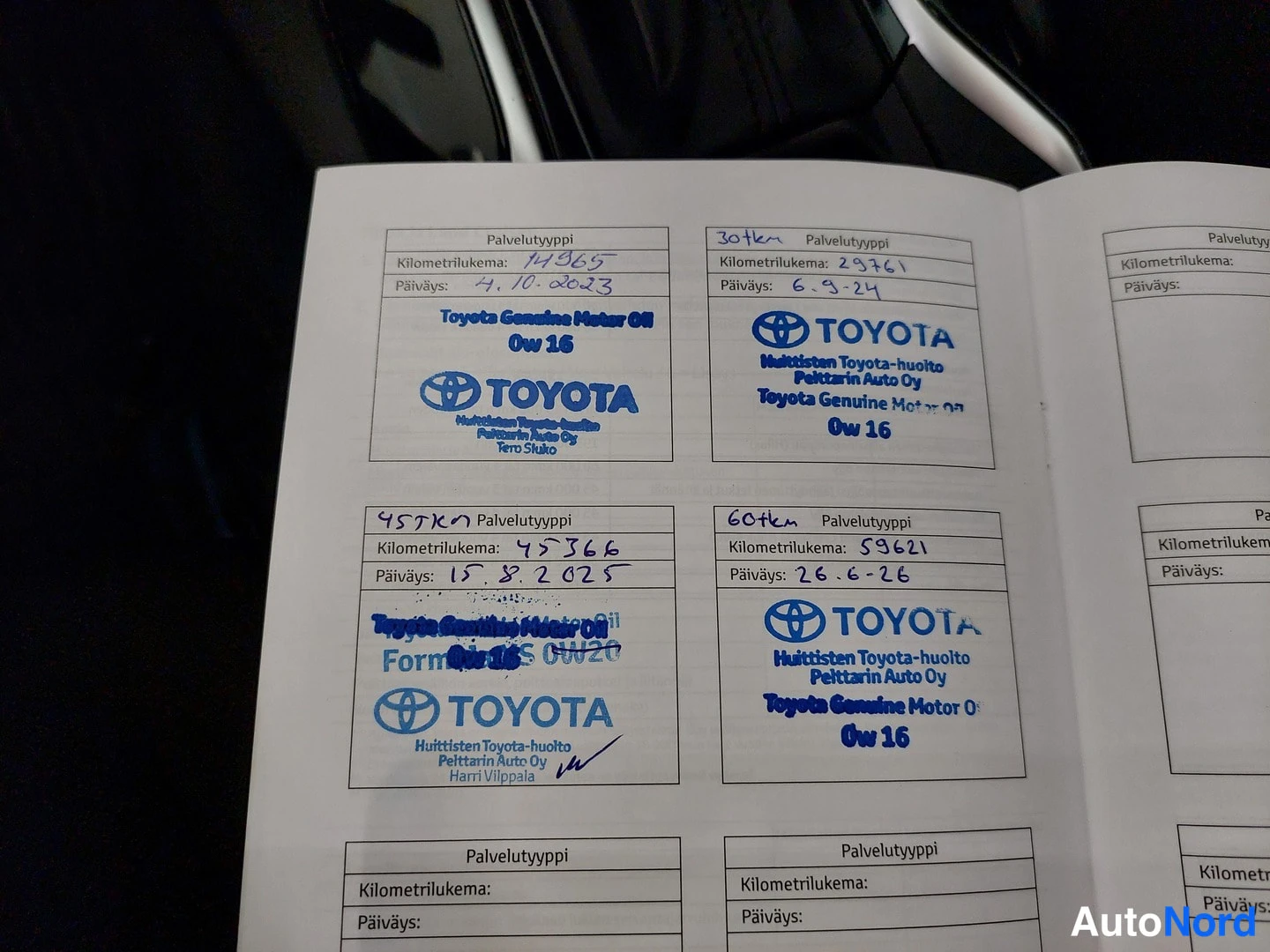 Muu: Huoltokirja sivu jossa neljä Toyota-huoltoleimaa kilometrilukemilla 14965, 29761, 45366 ja 59621.