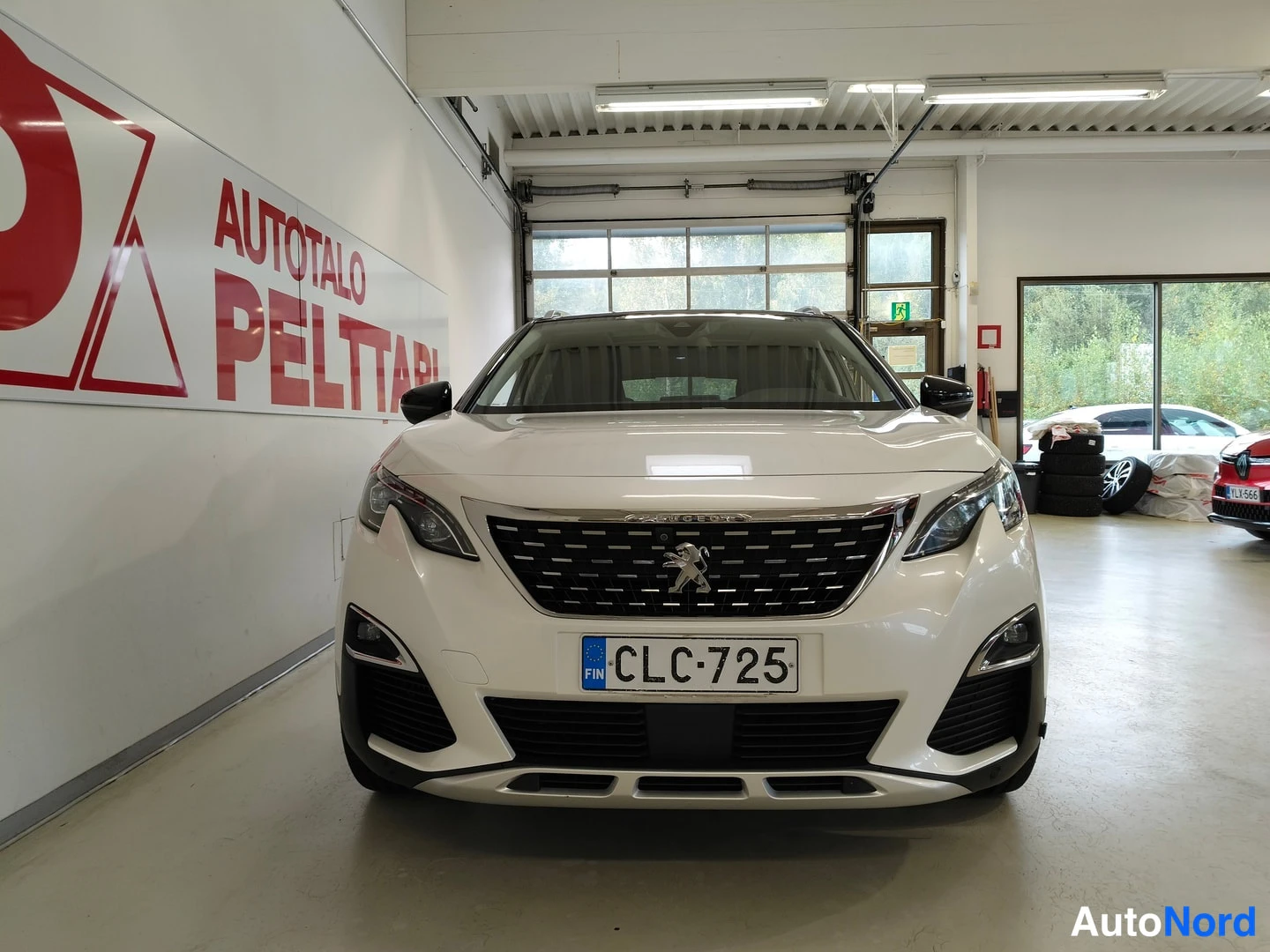 Edestä: Peugeot 3008 etupää suoraan edestä kuvattuna, valkoinen kori, musta etusäleikkö ja Peugeot'n leijonamerkki, rekisterikilpi.