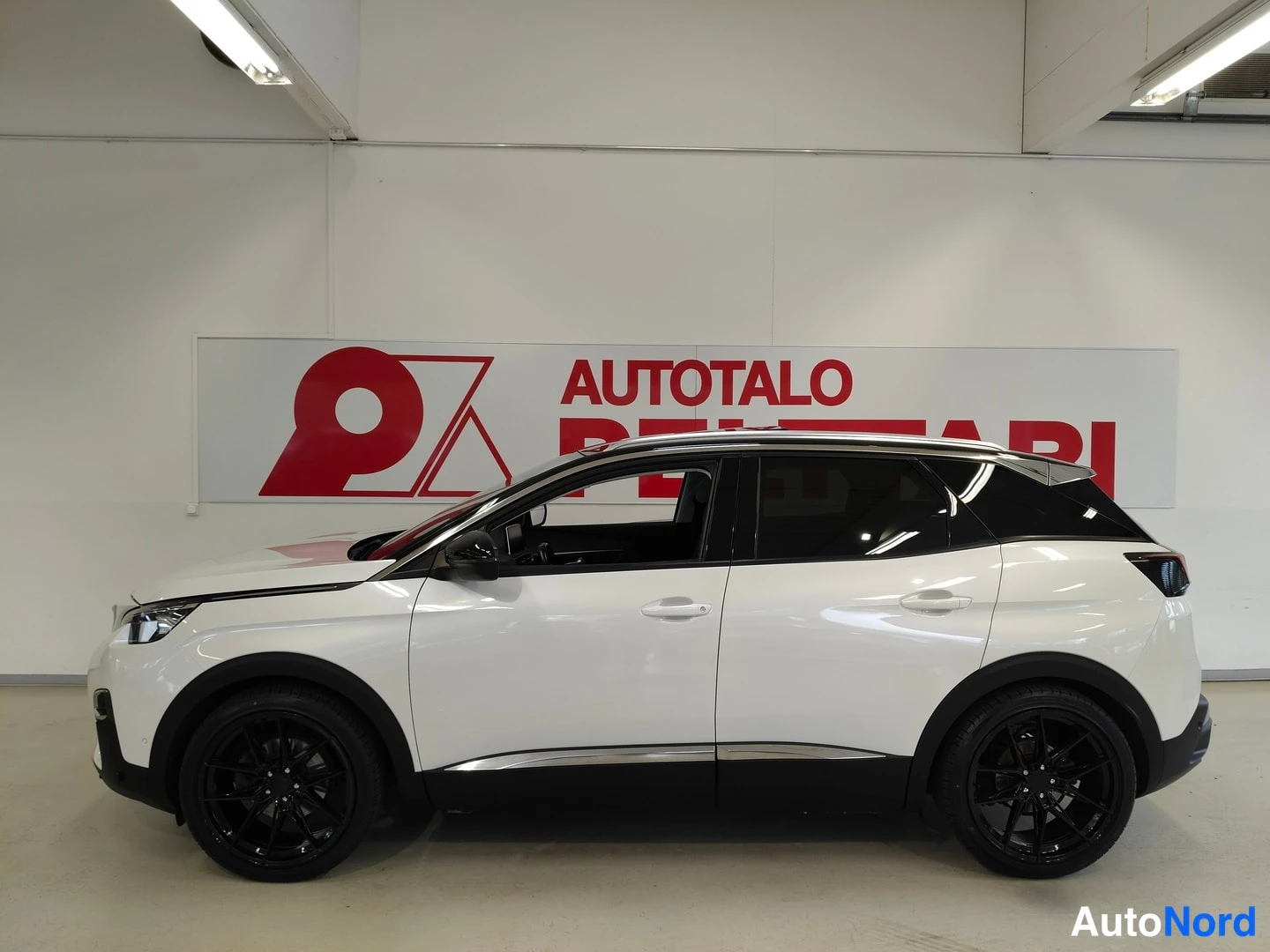 Takaviisto: Peugeot 3008 kyljeltä sivusta kuvattuna, valkoinen kori, mustat vanteet, kattokaiteet ja tummat ikkunat.