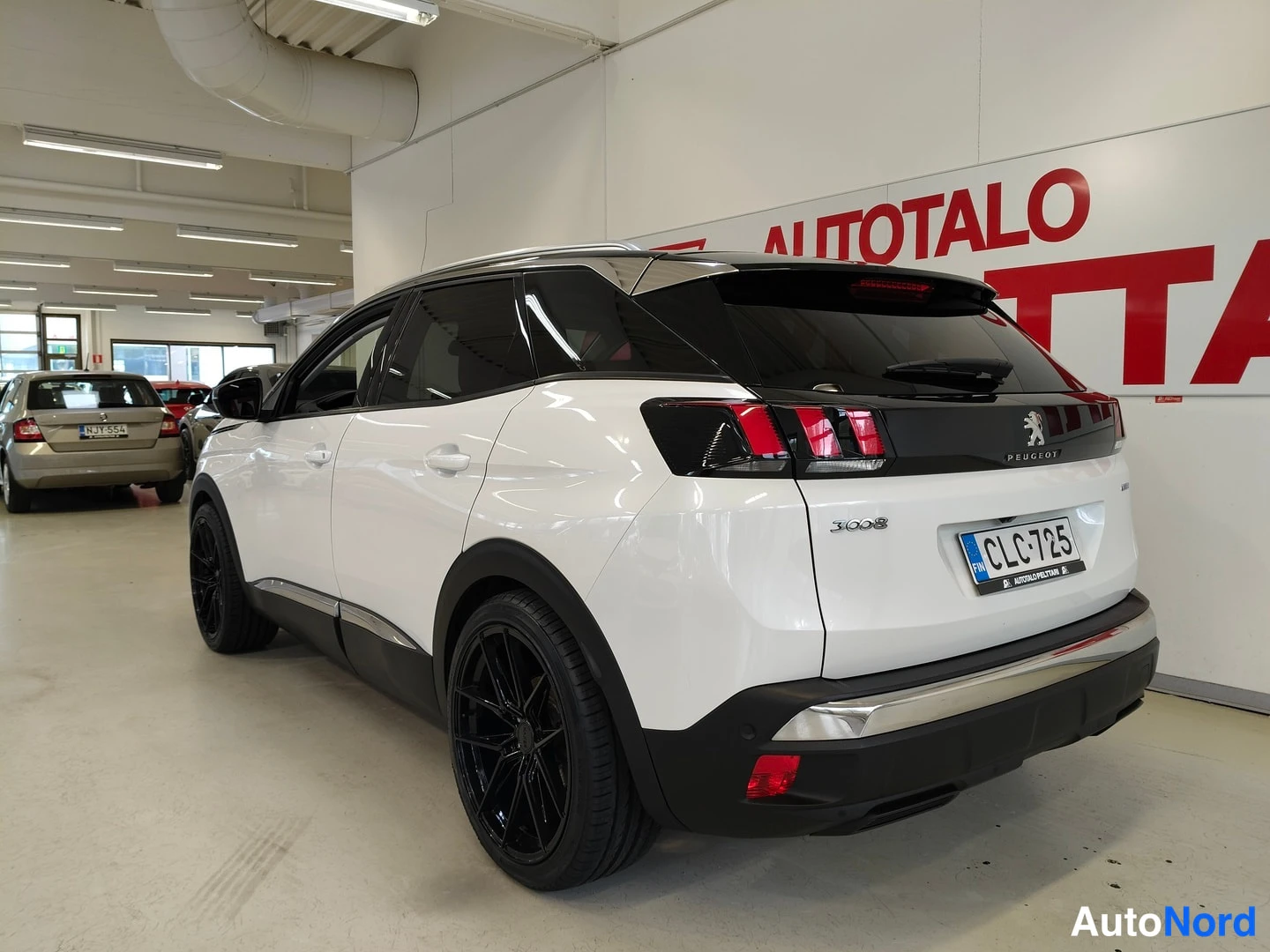 Takaviisto: Peugeot 3008 takapää kulmassa oikealta kuvattuna, valkoinen kori, musta takasiipi ja PEUGEOT-merkki, rekisterikilpi.