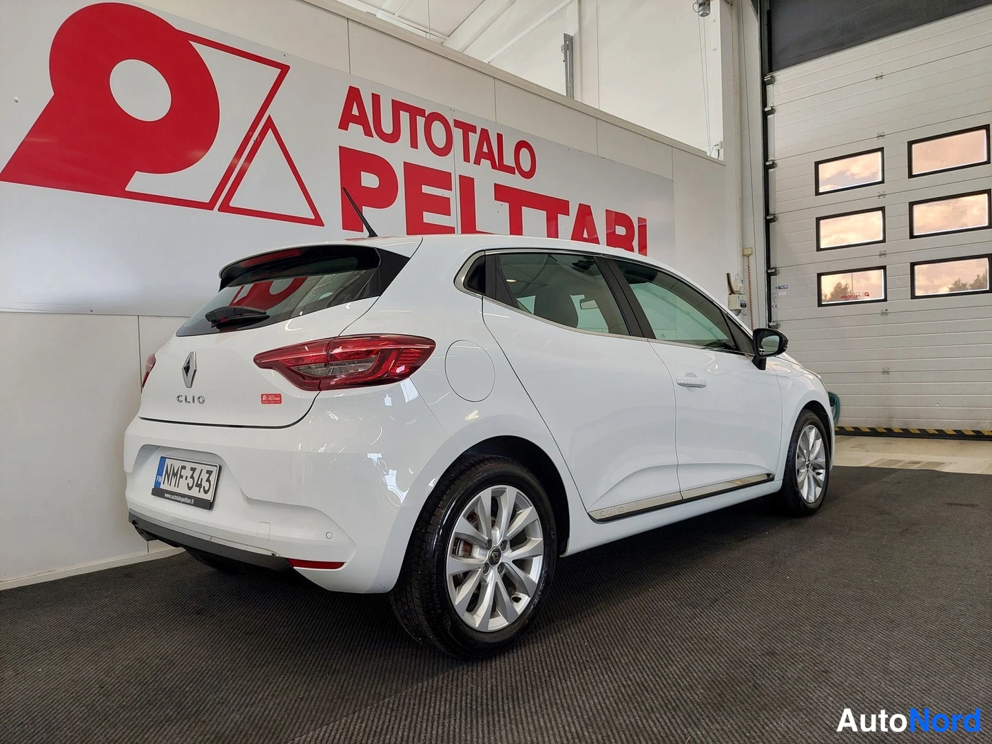 Takaviisto: Valkoisen Renault Clion takaosa ja oikea kylki kolmantelävinkulin, rekisterikilpi näkyvissä.