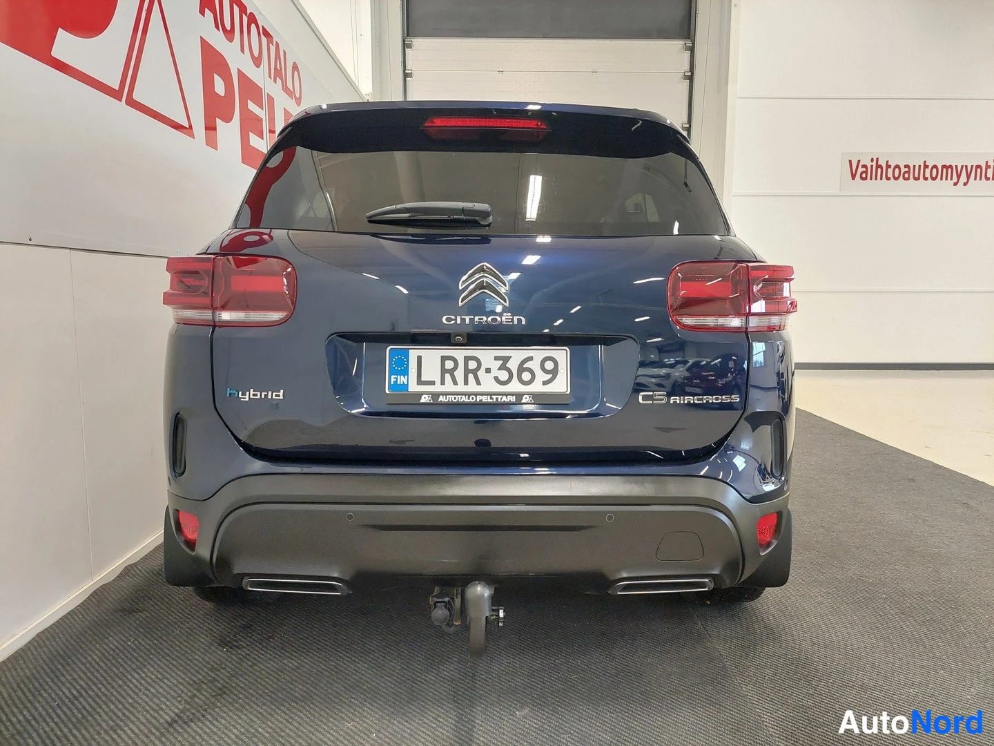 Takaa: Takaapikuvva tummansinisestä Citroën C5 Aircross -automobilista, rekisterikilpi, Hybrid-tunnuksella ja hinauskytkimellä.