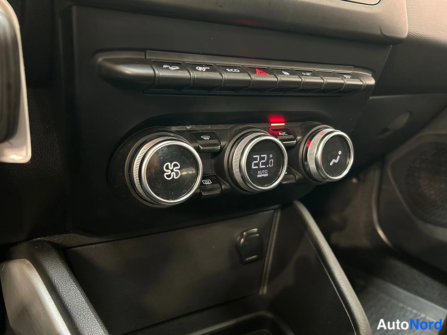 Yksityiskohta: Ilmastoinnin säätönupit, näytössä 22 astetta AUTO ja A/C-merkintä.