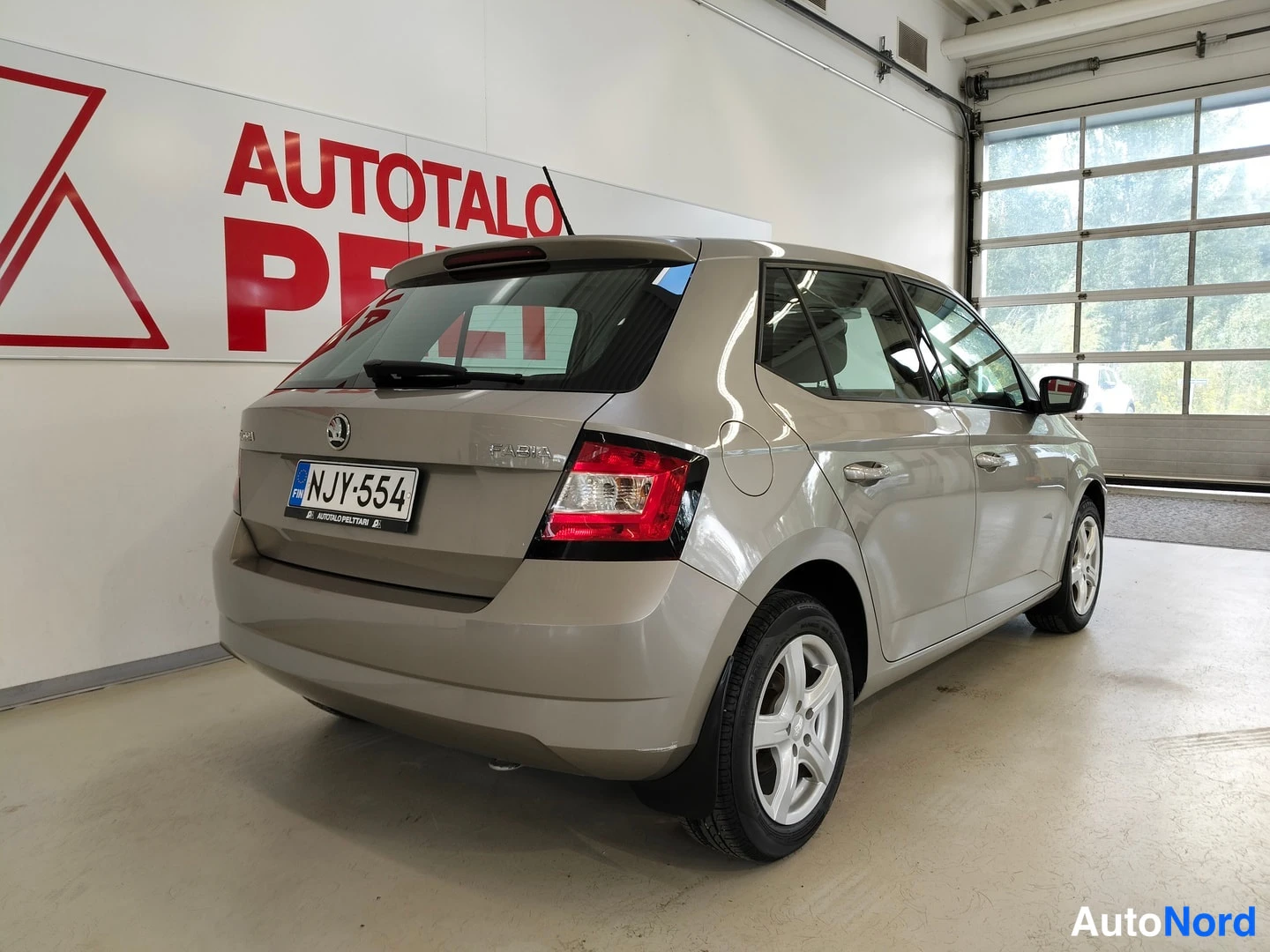 Takaviisto: Skoda Fabia takaa sivulta nähtynä, rekisterikilpi, auton takaosa ja oikea kylki näkyvissä.